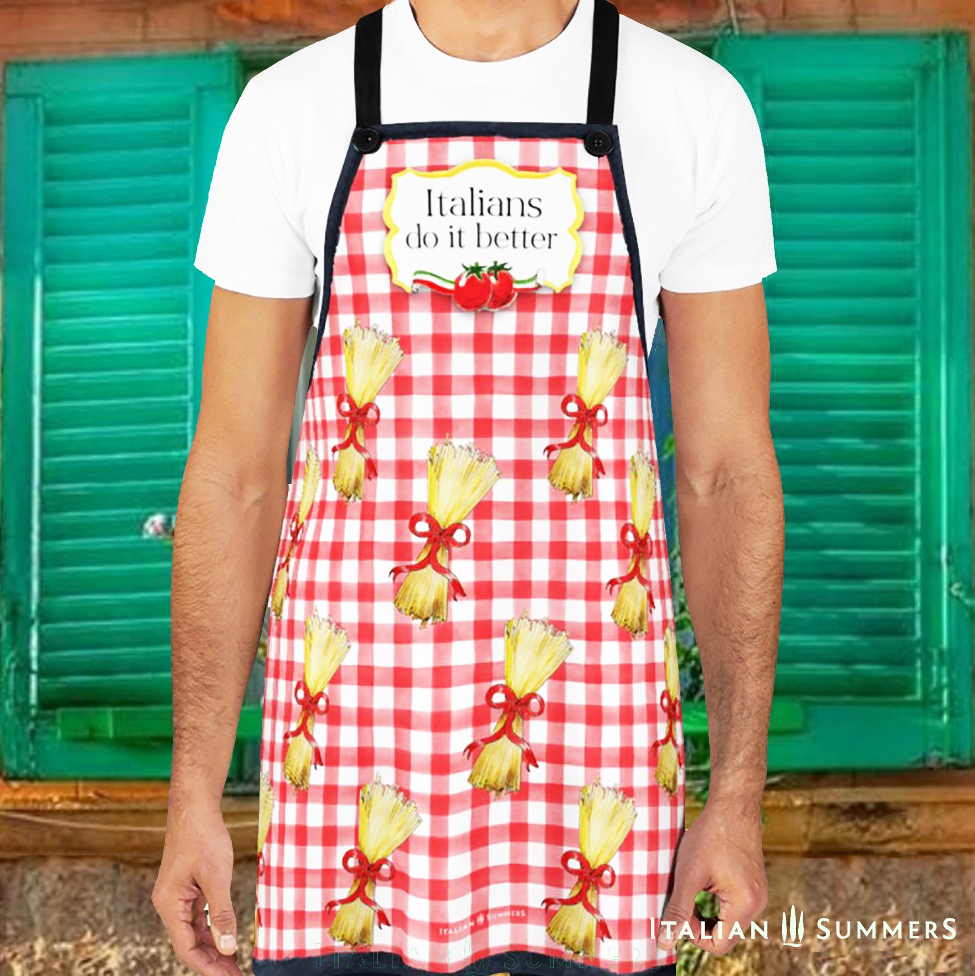 A happy red-checkered printed pattern apron with bundles of spaghetti with red bows . On the chest is a yellow  gold frame with the text: Italians do it better, and two happy tomatoes with an Italian  flag