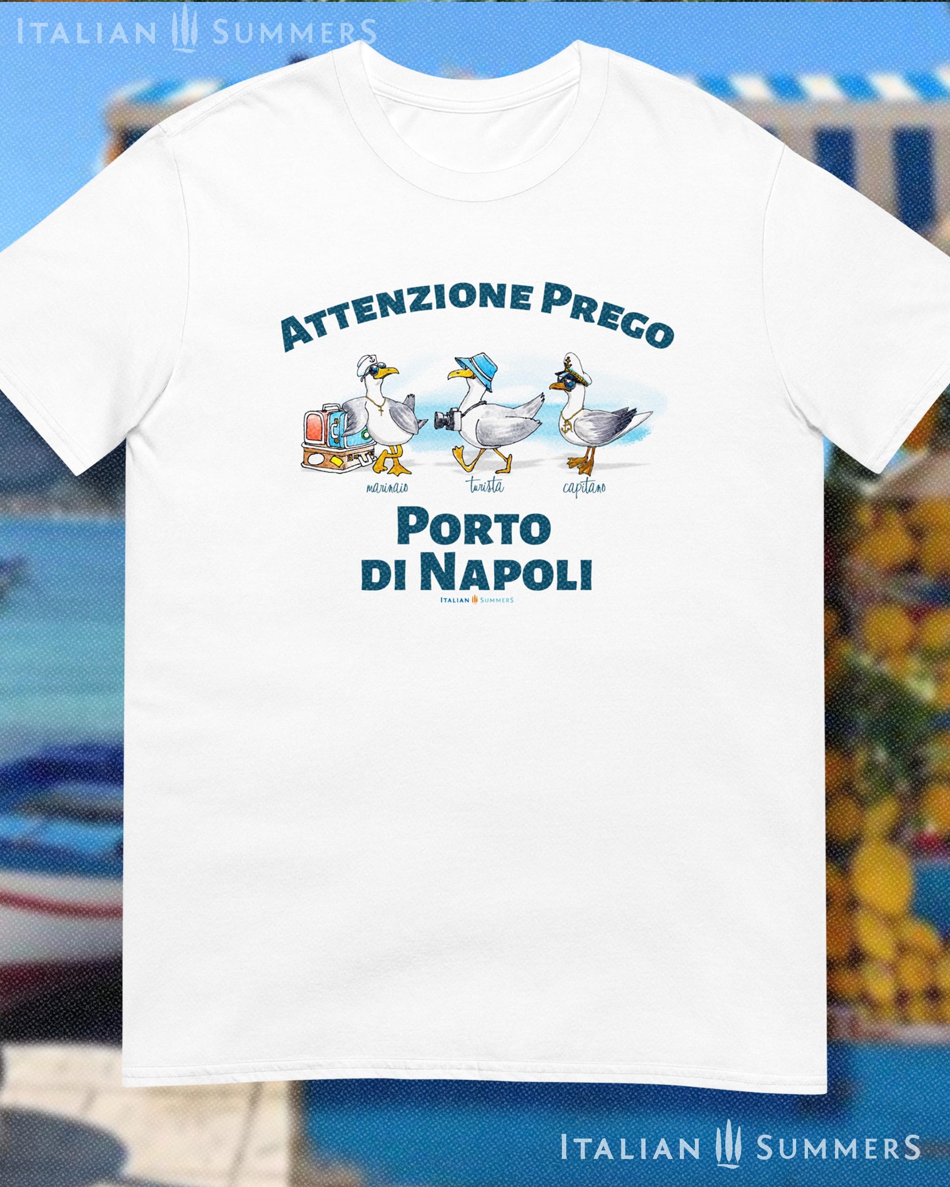 A cotton T-Shirt with the Italian text PORTO di NAPOLI in blue block letters and featuring the hand-drawn sketches of  three seagulls dressed up as a sailor, a tourist, and a boat captain.