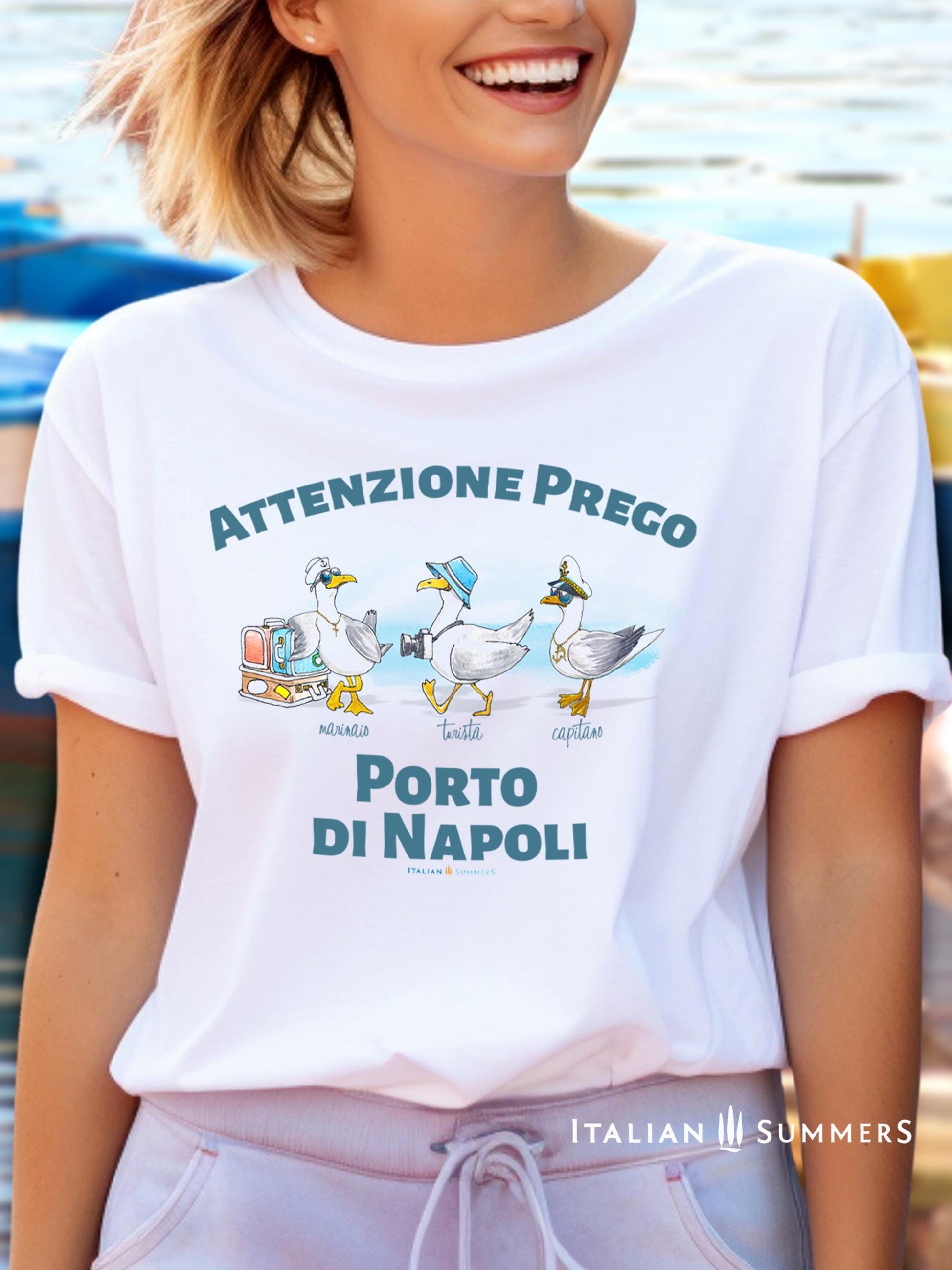 A cotton T-Shirt with the Italian text PORTO di NAPOLI in blue block letters and featuring the hand-drawn sketches of  three seagulls dressed up as a sailor, a tourist, and a boat captain.