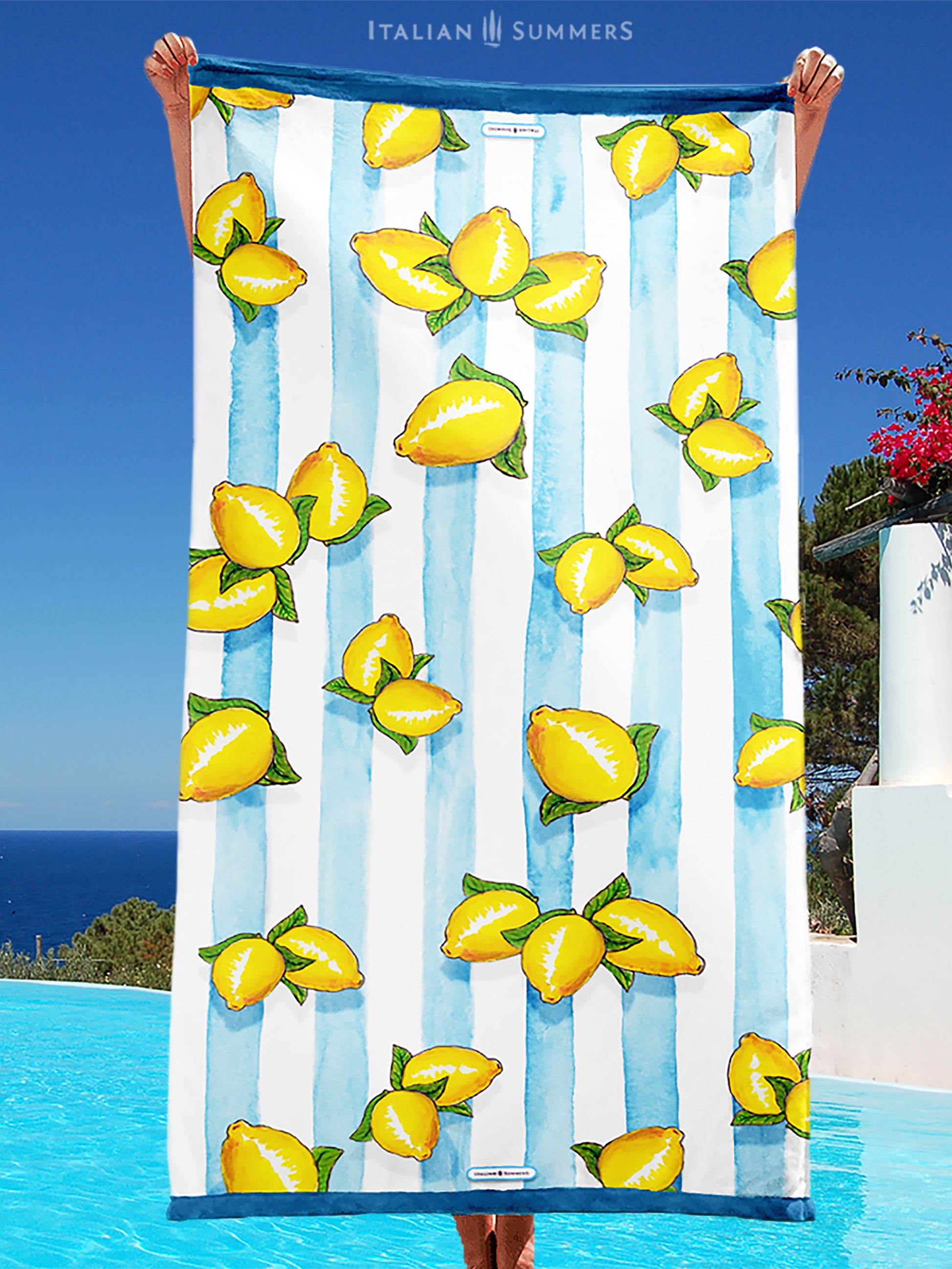 A large beach towel with printed Sorrento lemons on a background of aqua blue water color stripes. A happy and sunny Italian summer feeling. Made by Italian Summers
