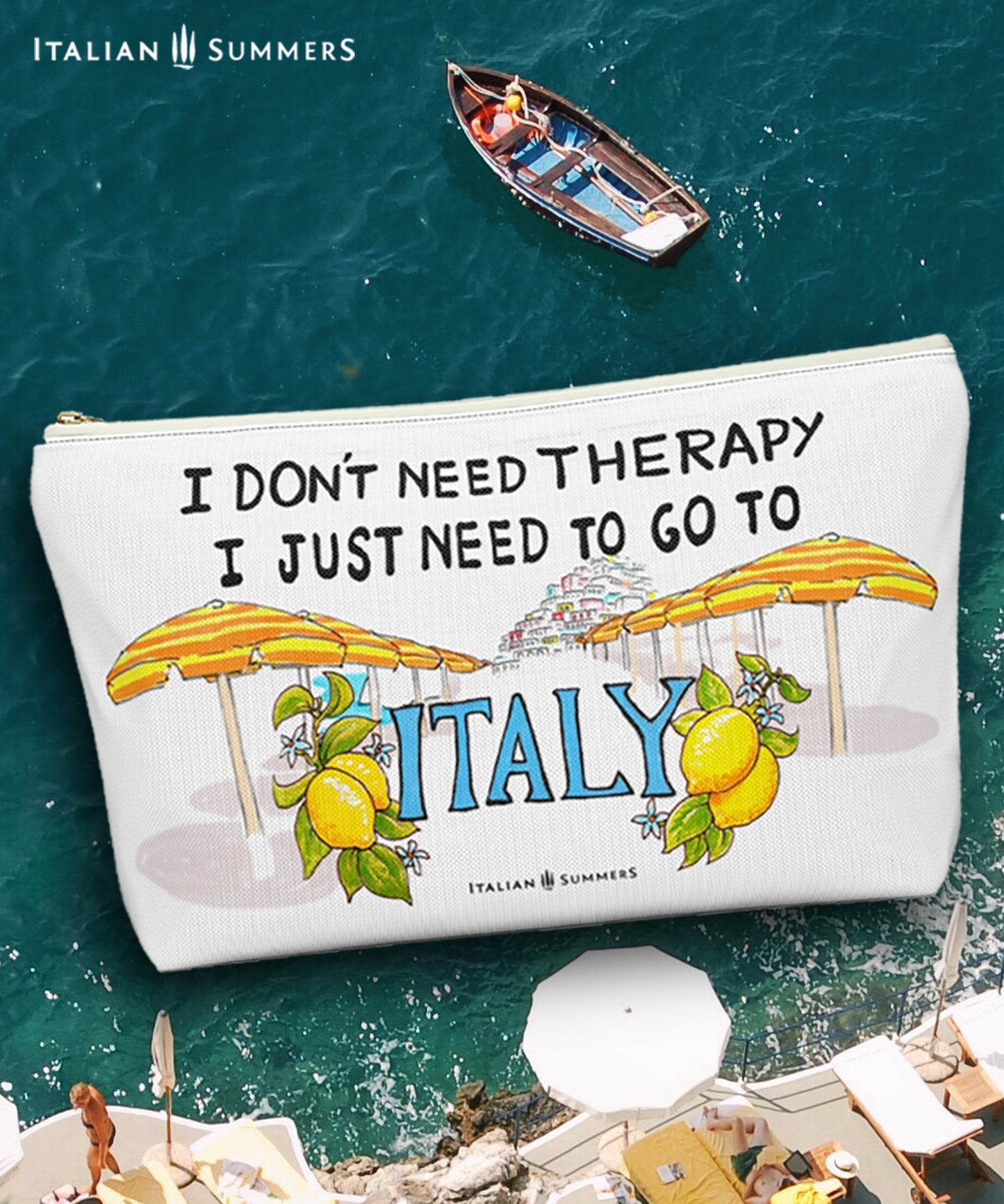 Italy inspired clutch of white canvas with he quote I don't need therapy, I just need to go to Italy. On the clutch there is a sketch of the beach umbrellas on Positano beach The beach umbrellas are yellow and orange striped. In the distance you ccan see the stagered houses of Positano. The word Italy in in big blue letters and is flancked with lemons. Designed by Italian Summers.
