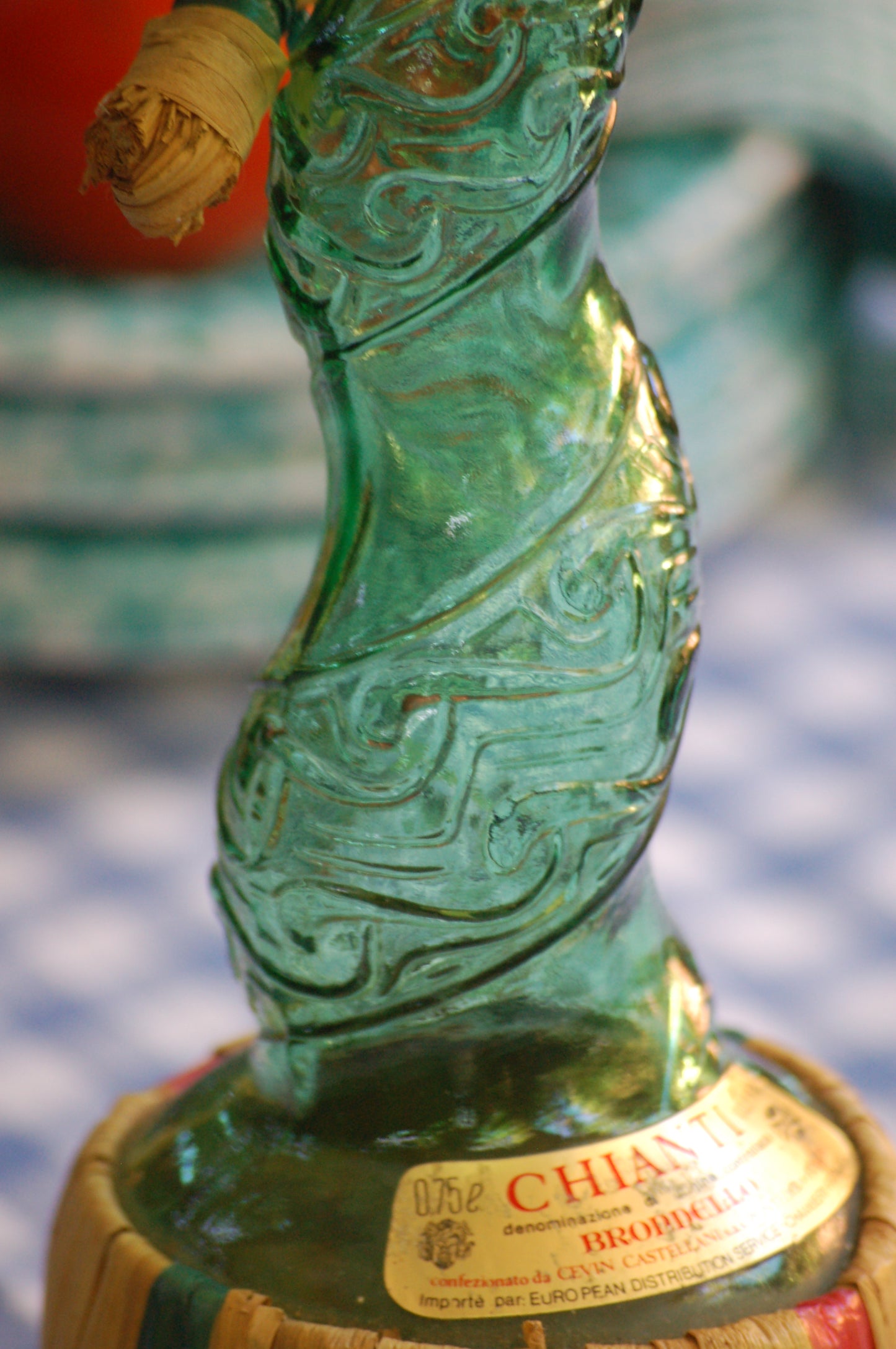 Empoli Genie Bottle, Chianti wicker glass flask, A beautiful Italian vintage wine decanter from the 1950s-60s. Emerald green glass and a spiraling floral embossing along the bottle's convoluted profile. true find