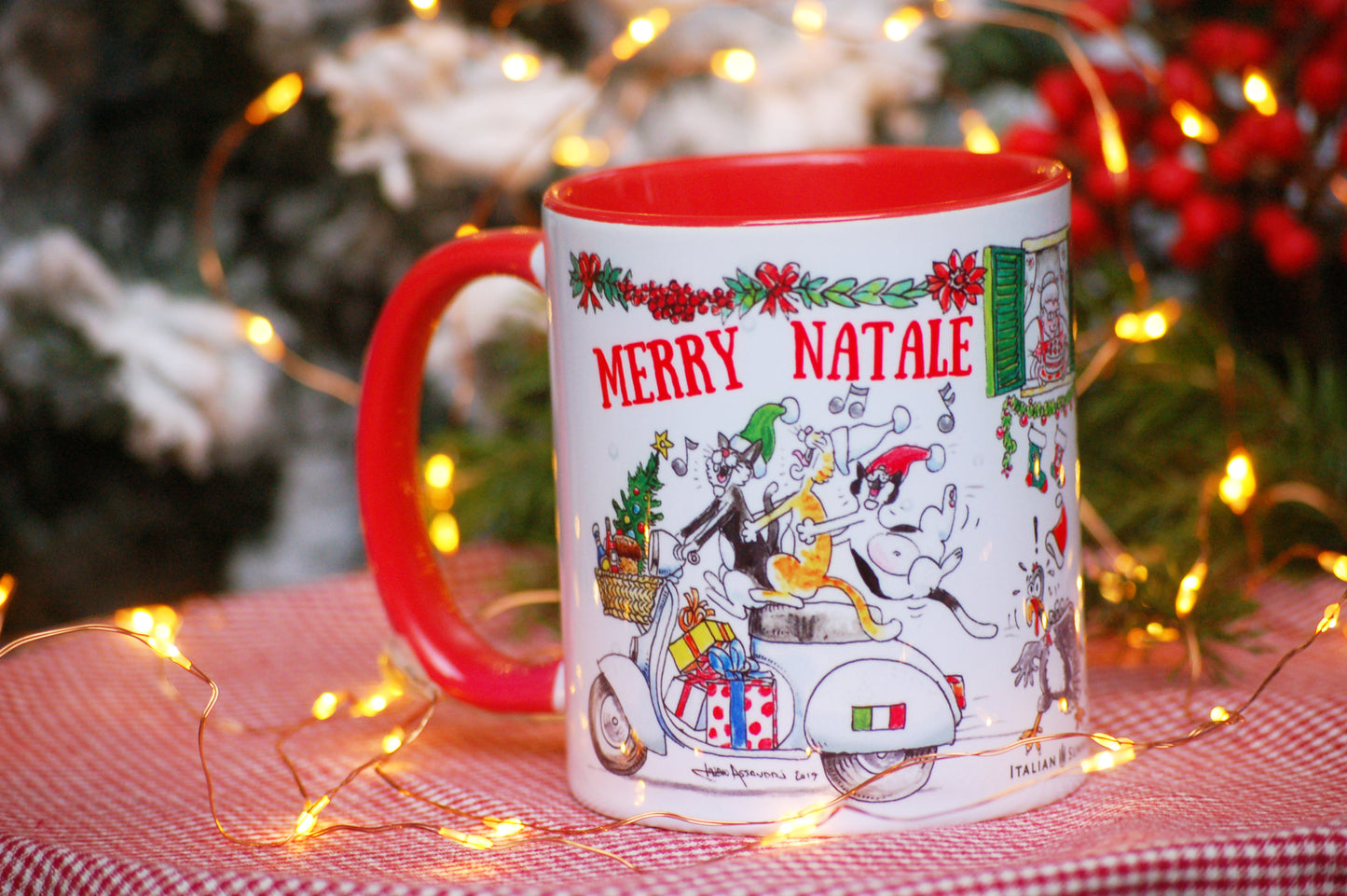 This Italy-inspired ceramic Christmas mug features the print of a merry trio of Italian cats singing carols on a vintage Vespa as they speed through an Italian street. A cute vintage red Fiat500 car zooms in the opposite direction with a Christmas tree on the roof!