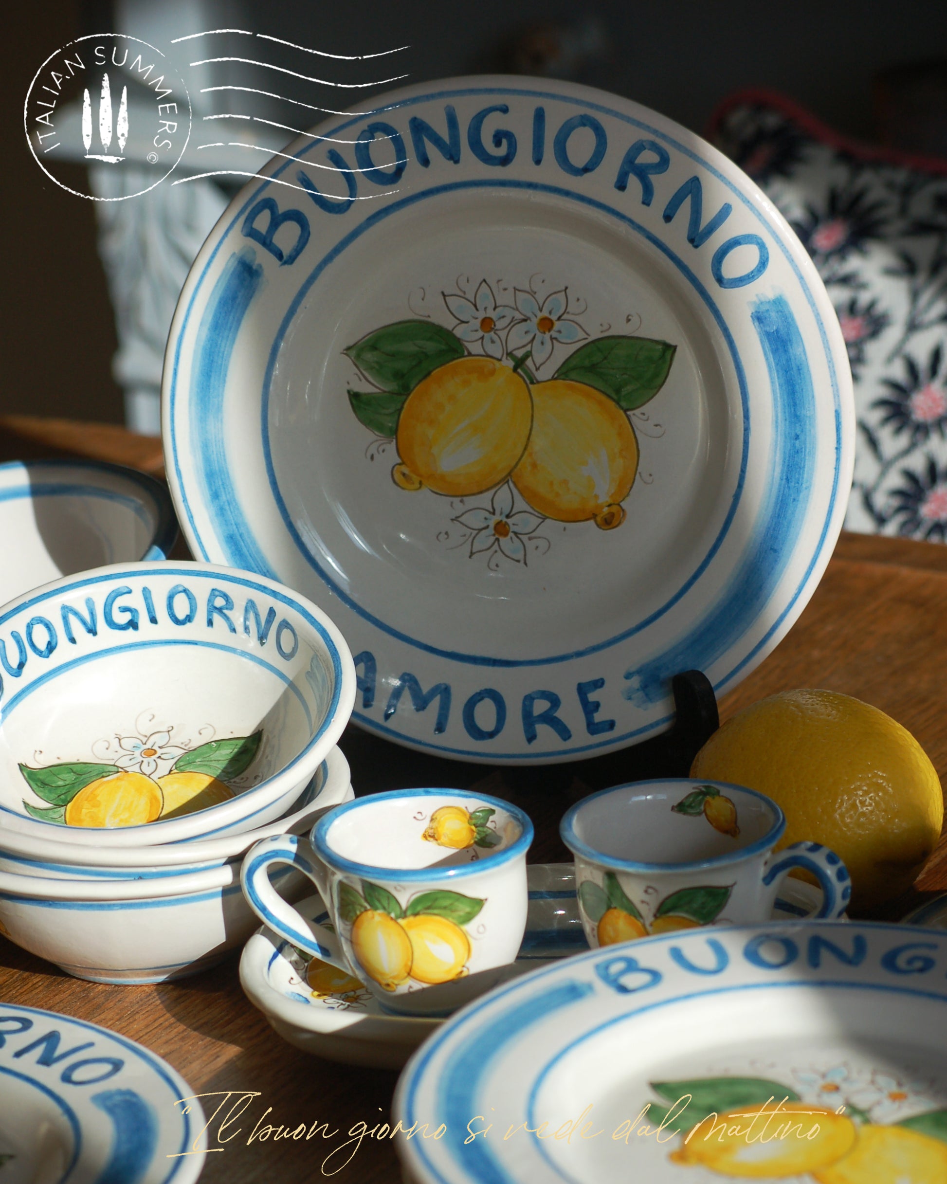 A bright and colorful Maiolica ceramic plate, hand made in Sicily featuring sunny Sicilian lemons and a blue decoration with the text, Buongiorno Amore, which means, Good Morning my Love in Italian.