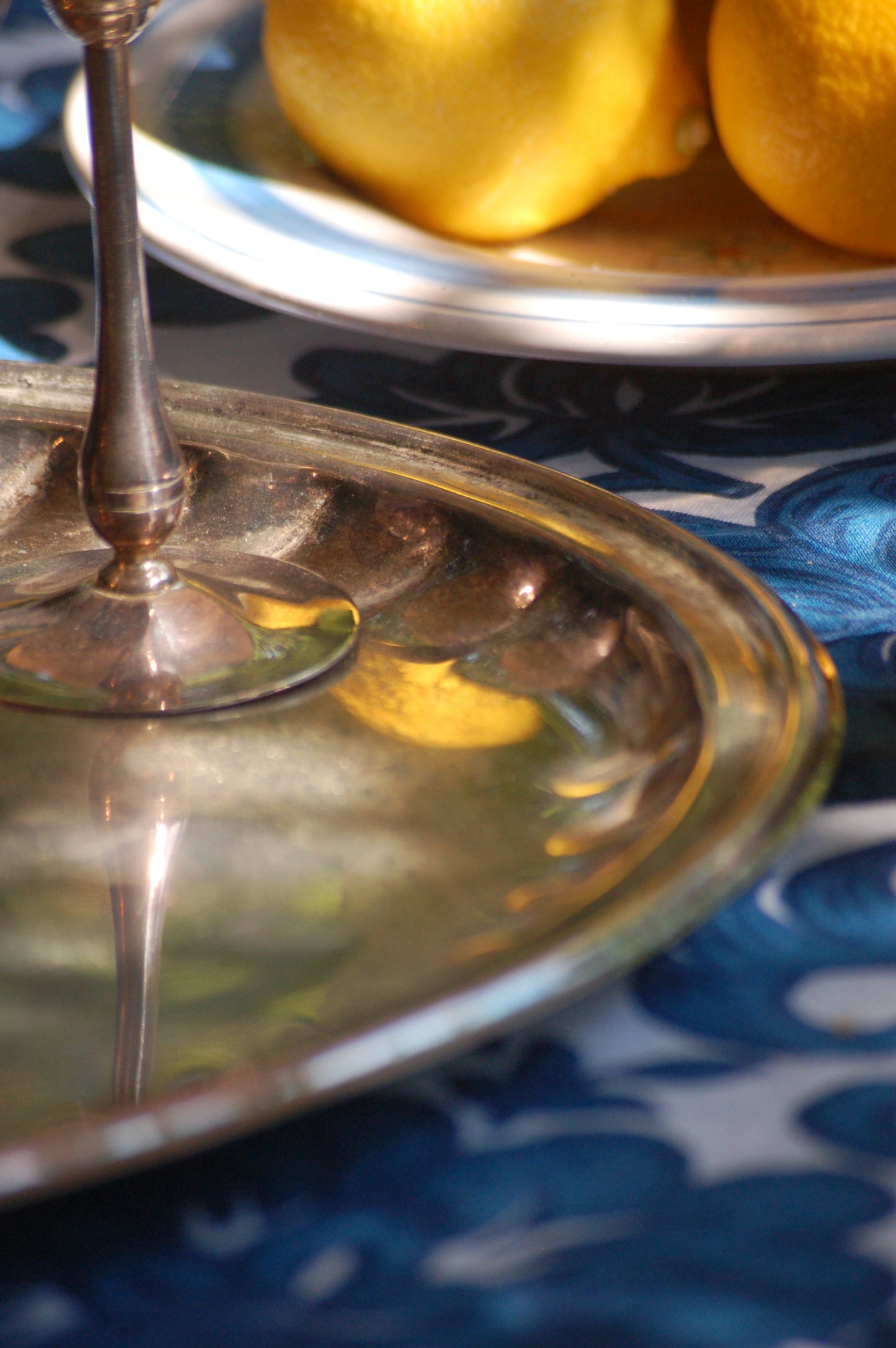 Italian Vintage Champagne coupes.set of six silver and gold plated long stemmed coupes on a silver plated tray upon a table with a flower blue Mediterranean pattern. A bowls with lemons is nearby along with white and blue maiolica serving bowls.,