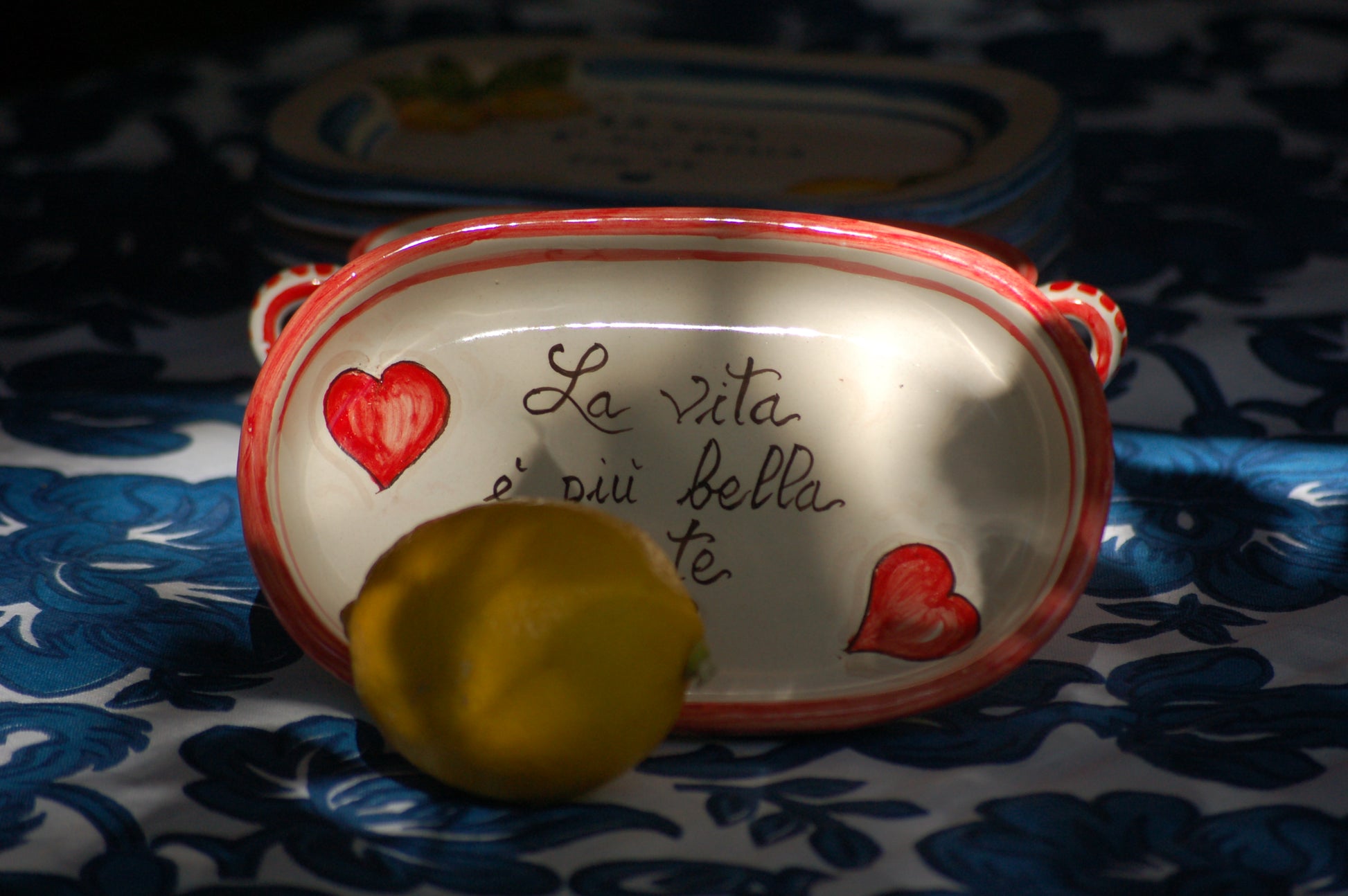 A bright and colorful Italian Maiolica ceramic espresso coffee set, two demitasse and a serving tray featuring happy Sicilian red hearts and a decoration with the Italian text -La vita e' piu bella con te-.  hand made in Sicily