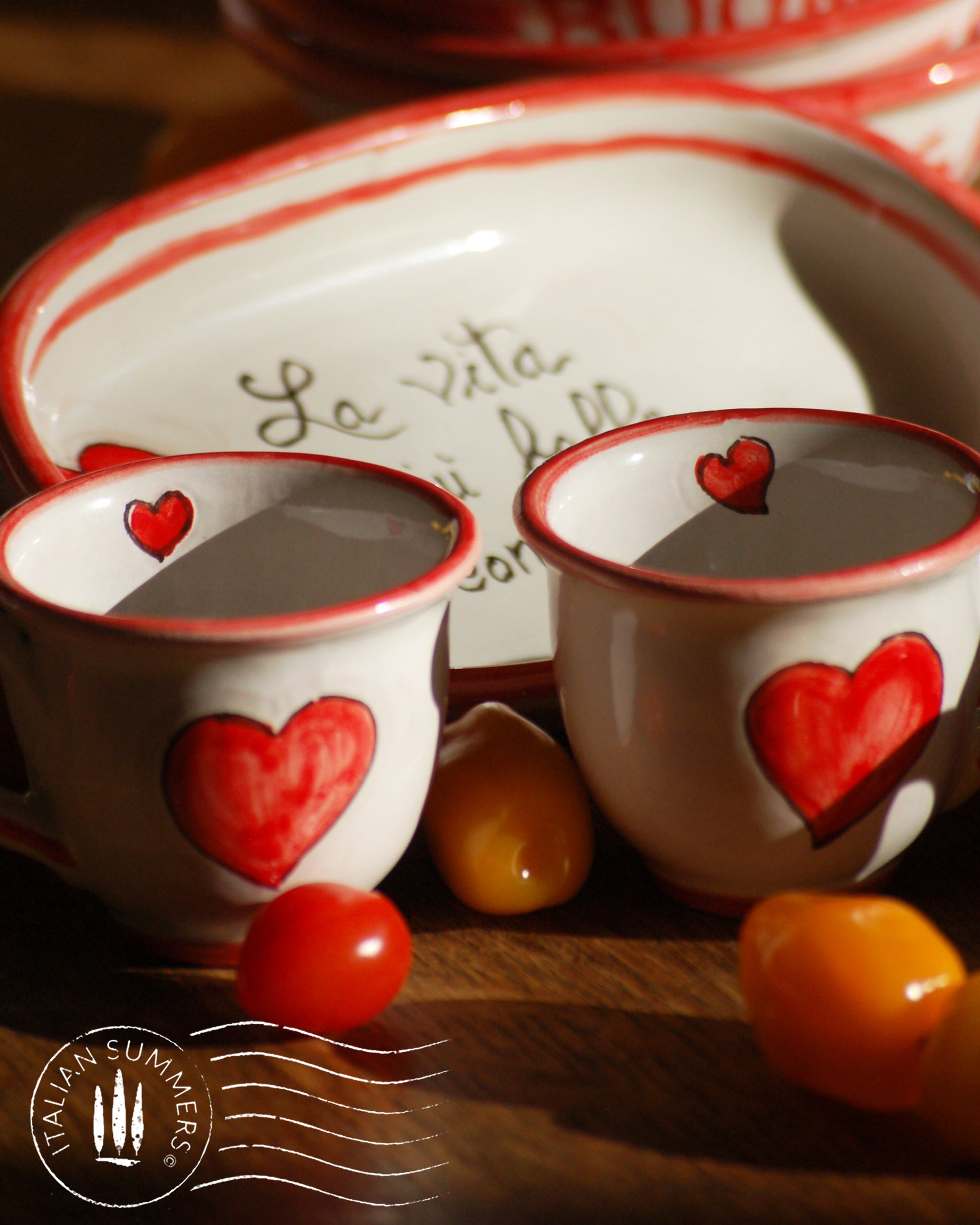 A bright and colorful Italian Maiolica ceramic espresso coffee set, two demitasse and a serving tray featuring happy Sicilian red hearts and a decoration with the Italian text -La vita e' piu bella con te-.  hand made in Sicily