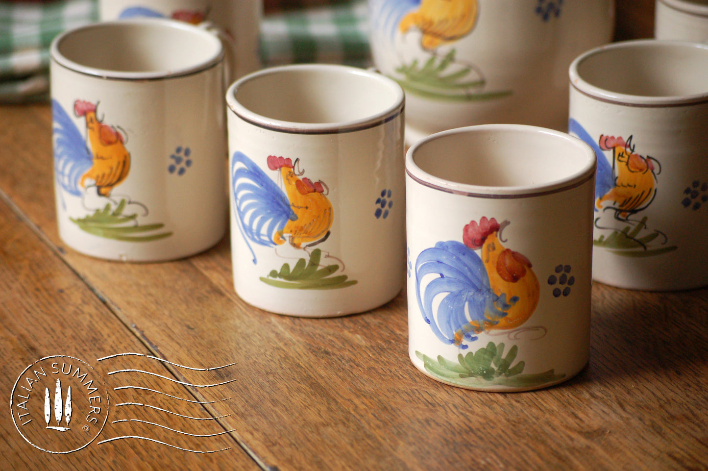 A set of Vintage maiolica ceramic six mugs and a carafe from Puglia, Italy. Each mug as well as the carafe are glazed with the traditional creamy white Grottaglie glaze, decorated with a hand-painted colorful rooster, symbol of good luck and prosperity.