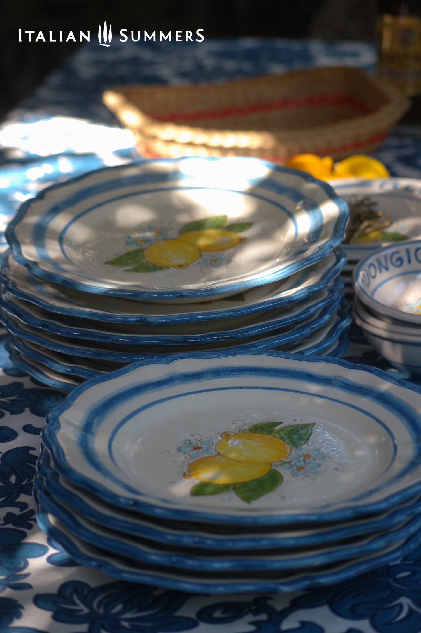 A custom made Italian maiolica ceramic dinner plate decorated with bright Sorrento Lemons and light blue stripes around the scalloped edge and in the inside of the plate framing the lemons.