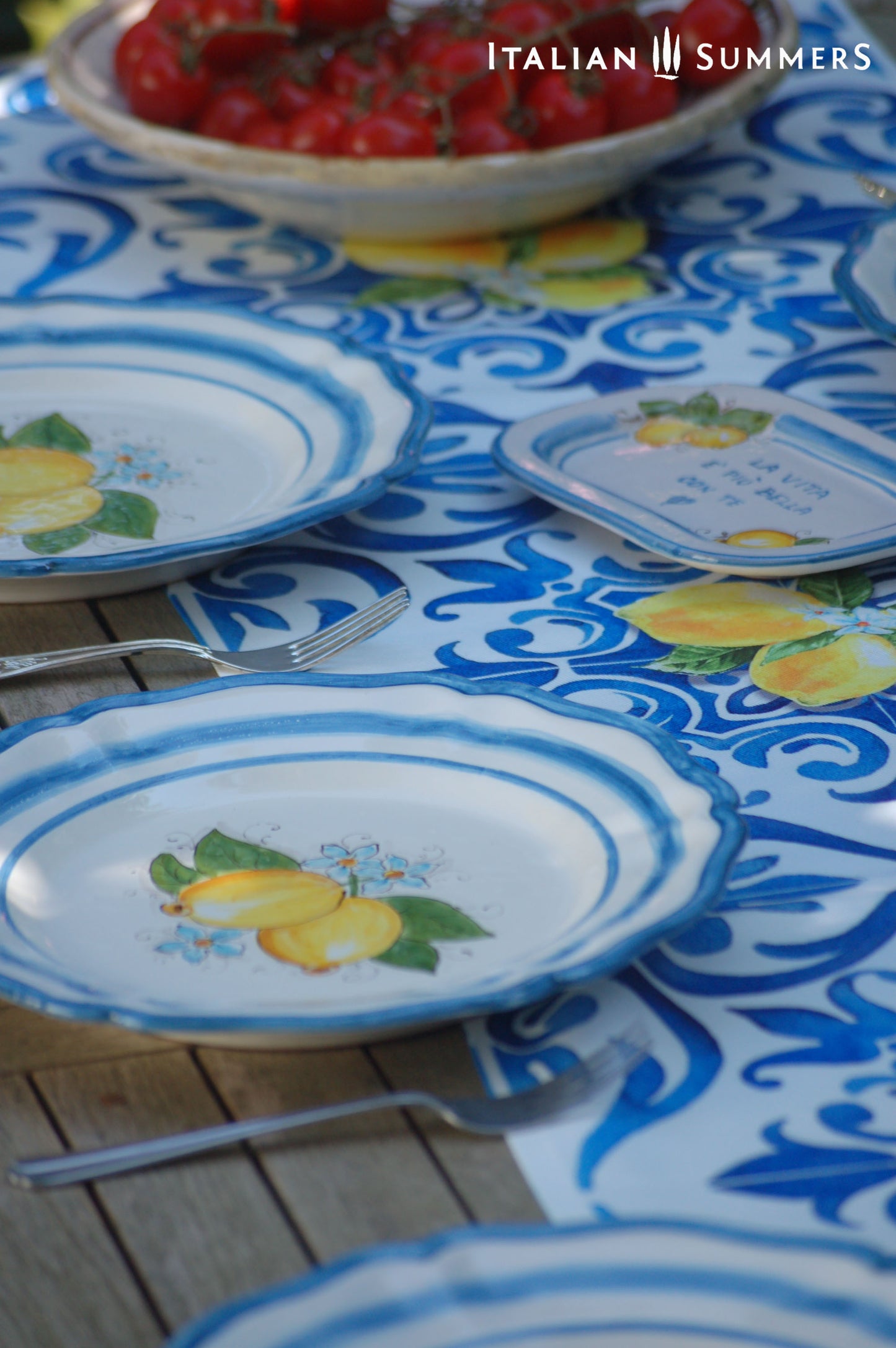A custom made Italian maiolica ceramic dinner plate decorated with bright Sorrento Lemons and light blue stripes around the scalloped edge and in the inside of the plate framing the lemons.