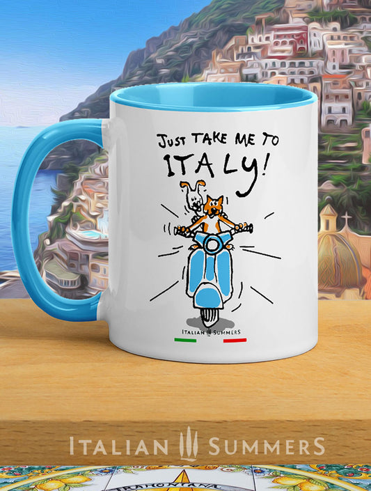 Italy inspired coffee mug with a sketch of a cat and dog, (seen from the front) driving to Italy. The red cat is driving, the white dog with brown floppy ears sits in the back and looks over the shoulder of the cat. A vintage blue Vespa. The mug has the quote Just take me to Italy! Made by Italian Summers