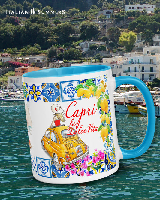 Capri inspired coffee mug with sketches of a yellow Cinquecento, the Faraglioni, a Riva and colorfu colorfull beach umbrellas. The rim is of the mug is decorated with Italian tiles and lemons. There is a lady in the Cinquecento who stand out of the sunroof. She has a hat and looks at the Faraglioni. Near the Yellow Cinquecento the is the writing Capri la Dolce Vita.  The coffee mug is available with a colored inside and handle in the colors blue, yellow and pink. Made by Italian Summers.