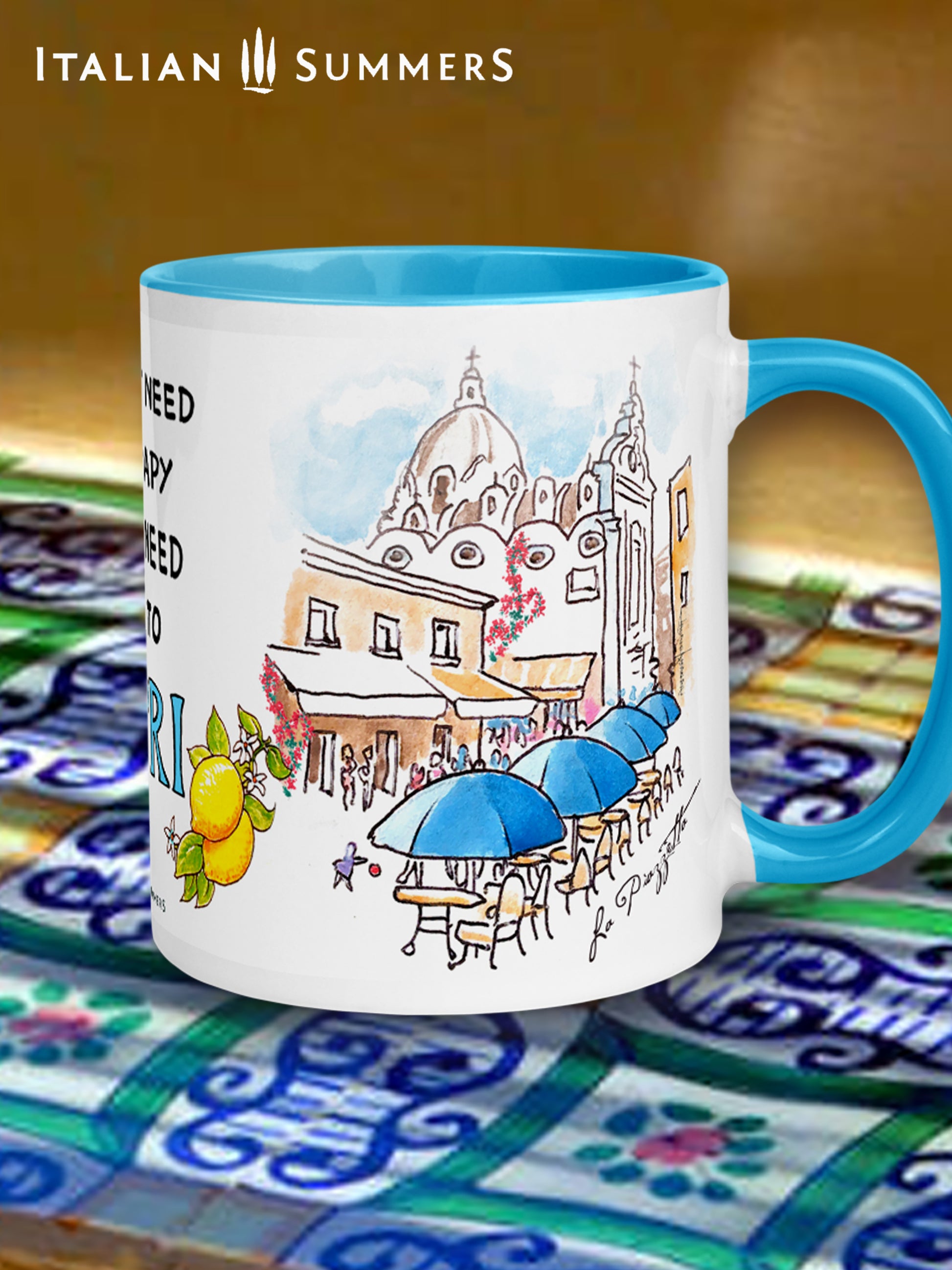 Italy-inspired white ceramic mug with blue colored handle and interior. Printed with a drawing of Capri's Piazzetta  with blue cafe Umbrellas and a crowd of shoppers strolling. The quote: I don't need therapy I just need to go to Capri is present . The word Italy is in blue Capital letters and flanked by bunches of Sorrento lemons with flowers. Made by Italian Summers