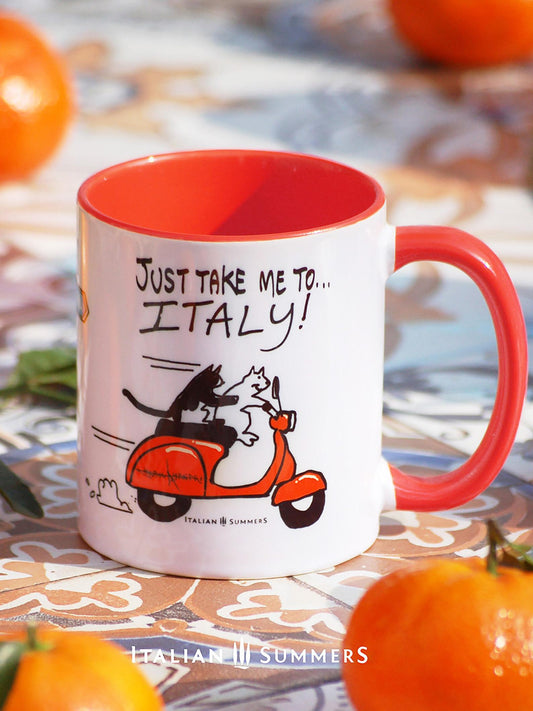 Italy inspired mug with a sketch of 2 cats driving on a vintage orange Vespa, with the quote "Just take me to Italy'. In the center of the mug is a sketch of a streetsign with the locations Positano and Tuscany. Made by Italian Summers