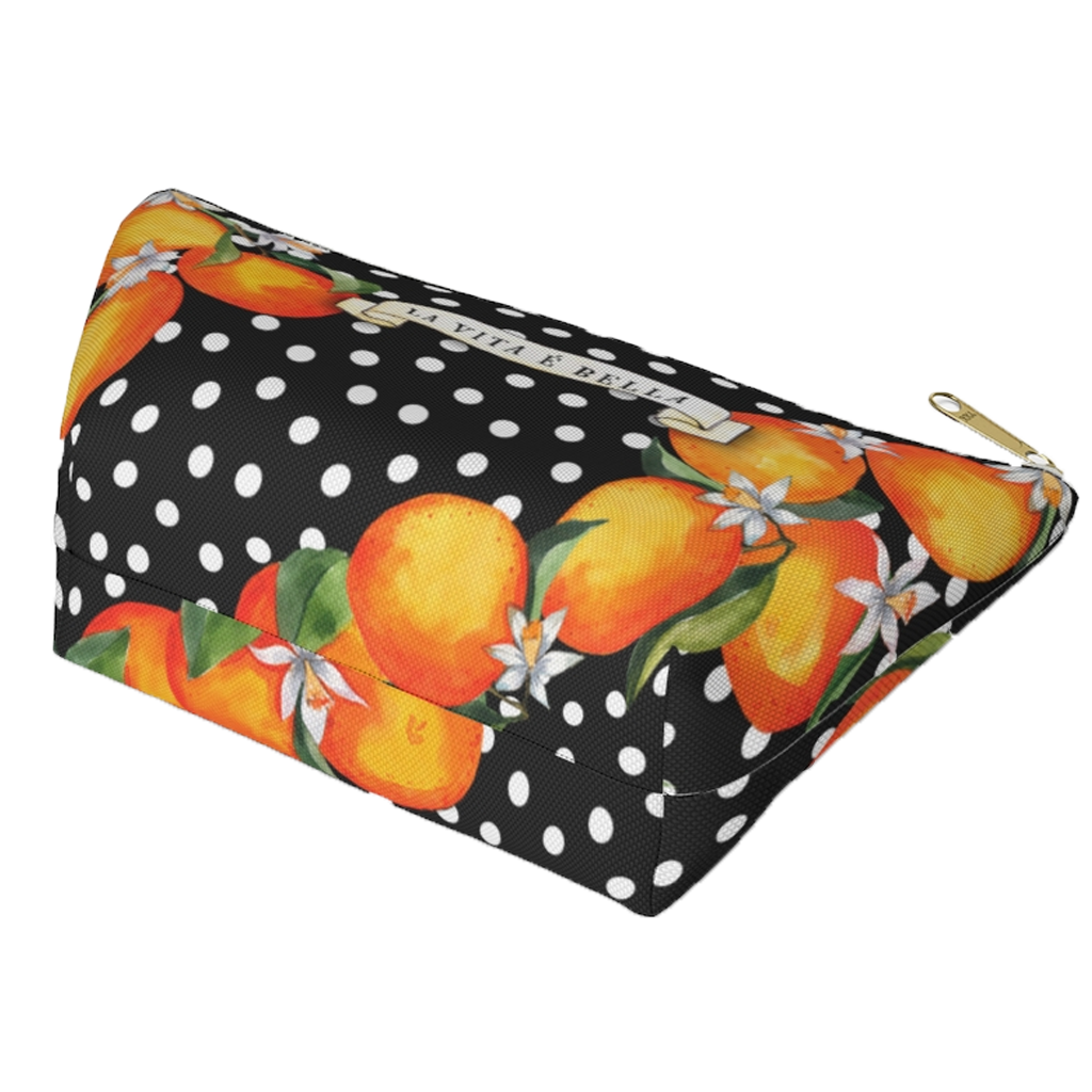 Made to order zippered canvas clutch printed with Sicilian oranges an blooms on a black field with white polka dots. a scroll on th front has the text LA VITA E BELLA.