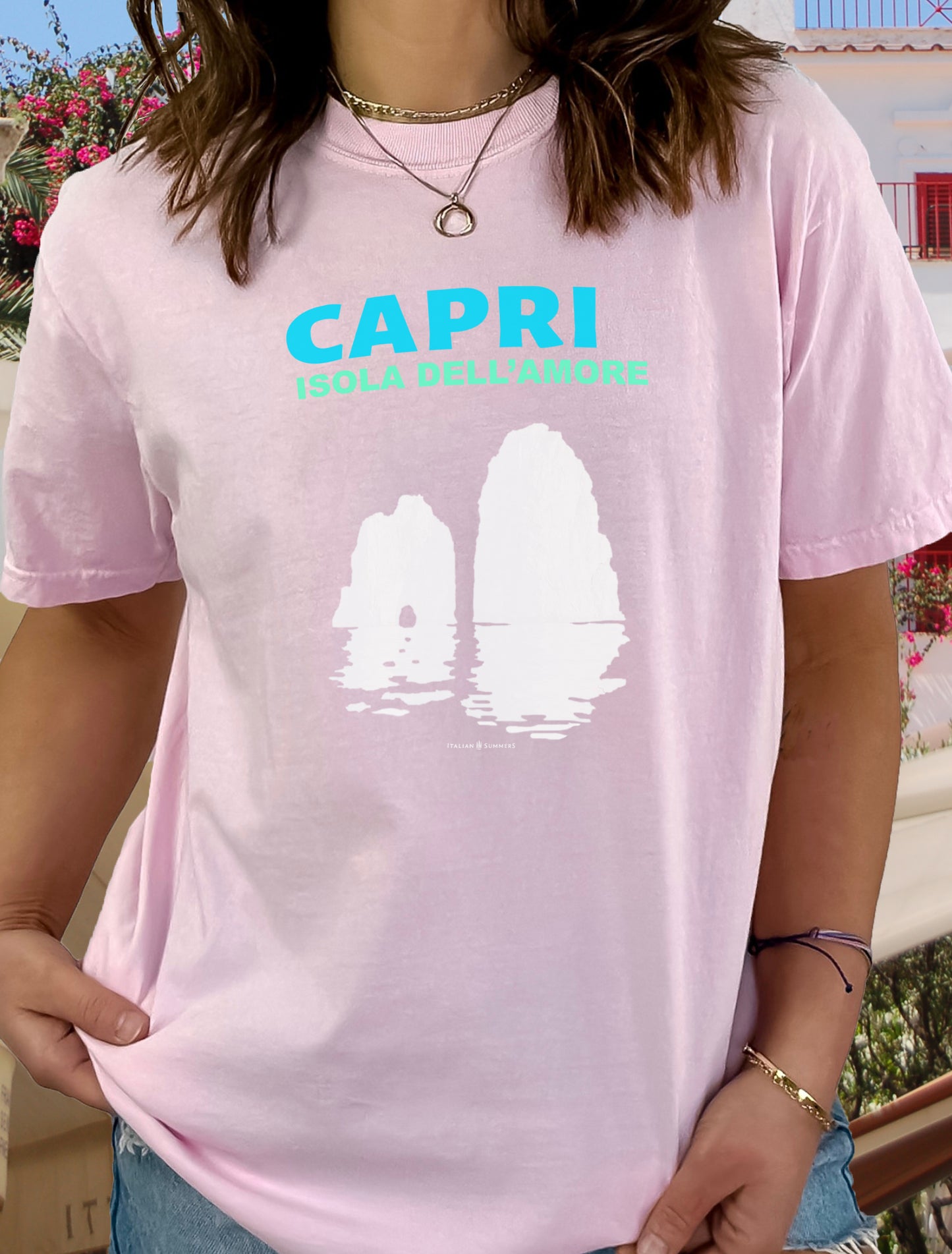 Italy inspired garment dyed T shirt with the aqua and white text: CAPRI, Isola dell'Amore (Capri, Iland of Love) with the silhouette  of the famous Faraglioni and their reflection umpon the waters of the Mediterranean Sea. Made by Italian Summers