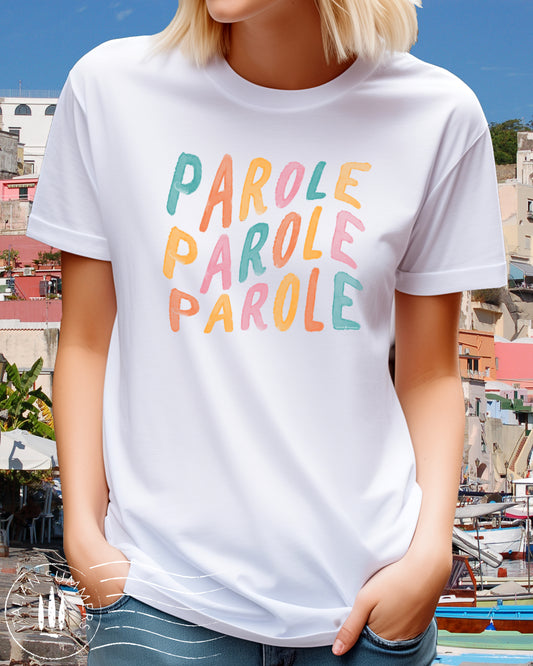 A girl is wearing an all-cotton white t-shirt with a colorful Italian quote in soft pastel tones: 'parole, parole, parole', reminiscent of Mina's famous Fab 70s song. Perfect to evoke that cheerful feeling when you wear it!