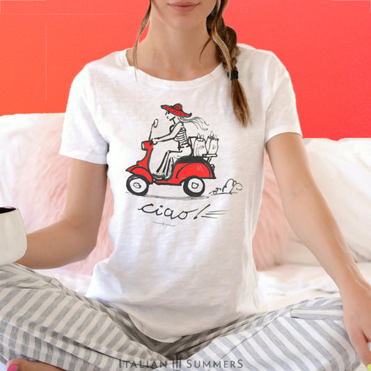 Italy-Inspired white T shirt VESPA CIAO, features a print of our original handpainted design of a fashionable girl with a big summer straw hat speeding through an Italian town with shopping bags on a vintage red Vespa.