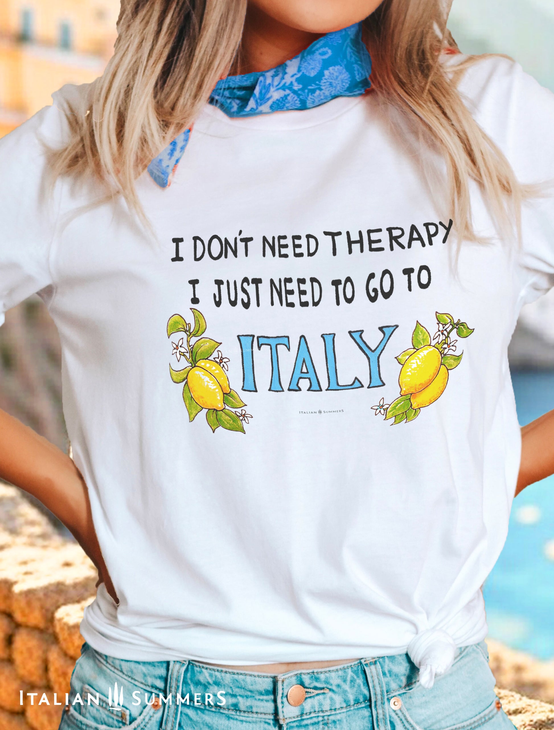 A happy cotton T shirt featuring the text: I dont need Therapy, I just need to go to Italy. The phrase is flanked by two bunches of leafy Sorrento Lemons from the Amalfi Coast, and the word ITALY is in a light marine blue. By Italian Summers