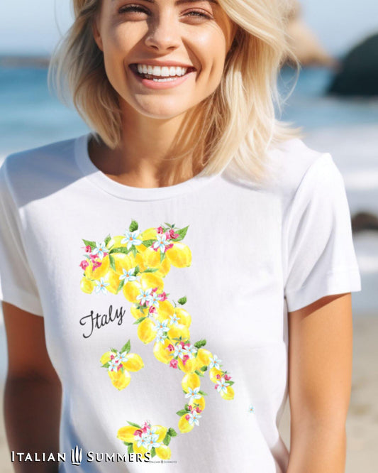 A  woman wearing a white cotton T Shirt with a print of a Colorful map of Italy made up of Sorrento Lemons with lemon blooms and bougainvillea flowers perfect for travel lovers.