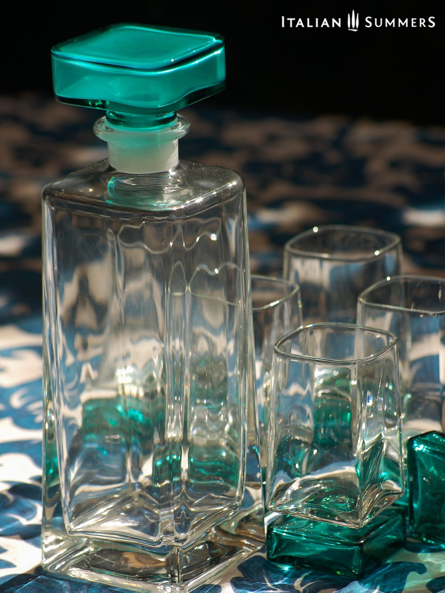 Vintage Bormioli Monet glass set from Italy, featuring square whiskey glasses with bold green foot and matching decanter, displayed on a table in retro style.