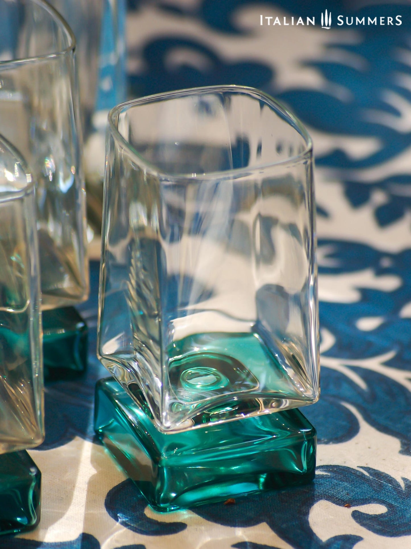 Vintage Bormioli Monet glass set from Italy, featuring square whiskey glasses with bold green foot and matching decanter, displayed on a table in retro style.