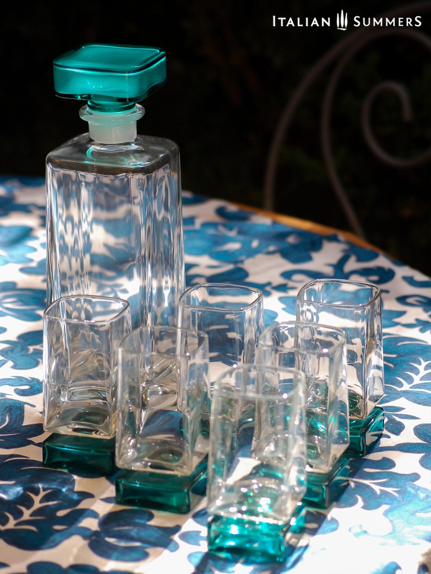 Vintage Bormioli Monet glass set from Italy, featuring square whiskey glasses with bold green foot and matching decanter, displayed on a table in retro style.