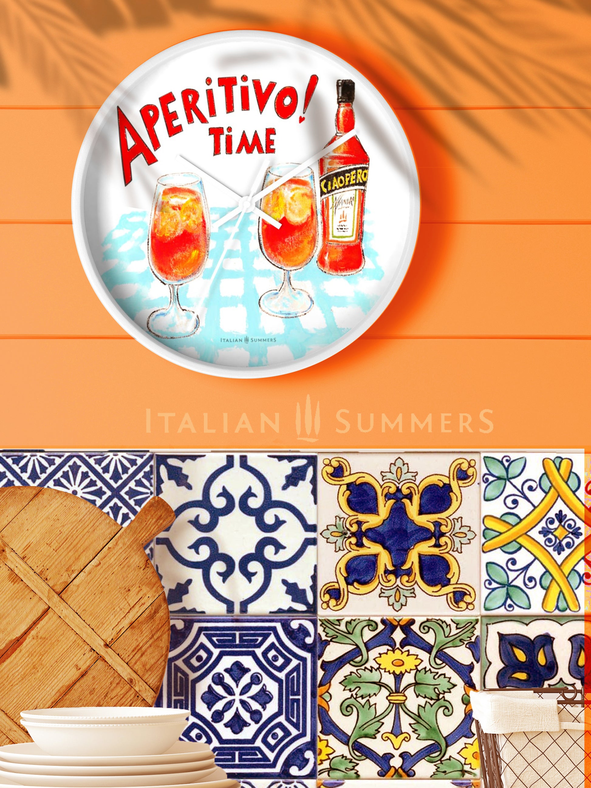 An Italy inspired rond clock with a print of Two glasses and a bottle of Aperol, whizh is called in the sketch Ciaoperol. The bottle and the foot glasses are standing on a light blue checkered table cloth. There is on top of the sketch the text 'Aperitivo time!' in a vintage red color, handwritten font. Made by Italian Summers
