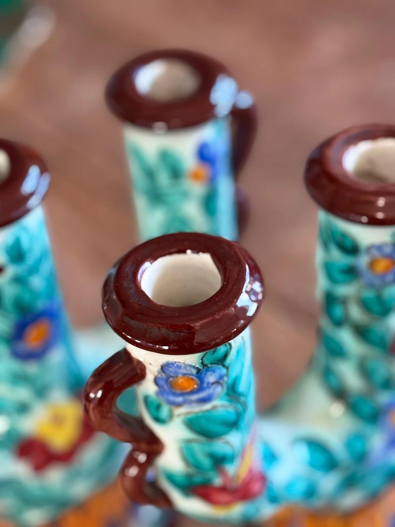 Decorative ceramic candleholder by 'Cerart' with floral patterns on a brown background