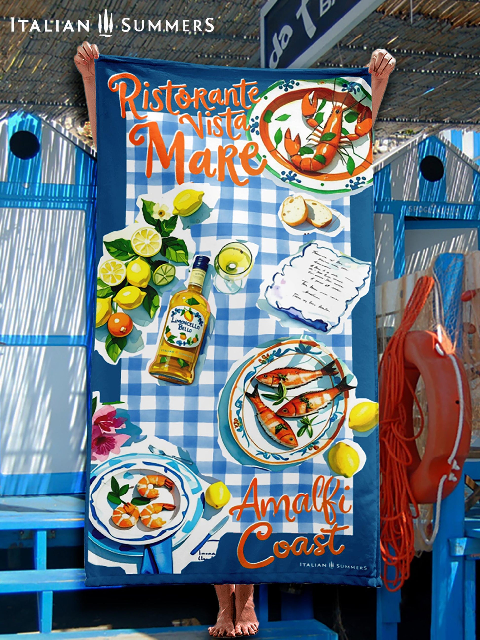 A beach towel featuring a blue rim with blue and white checkered patterns, hand-painted cut-out illustrations of Italian seafood, lemons, and limoncello, with the texts “Ristorante Vista Mare” on top and “Amalfi Coast” on the bottom, evoking an authentic Italian seaside trattoria vibe