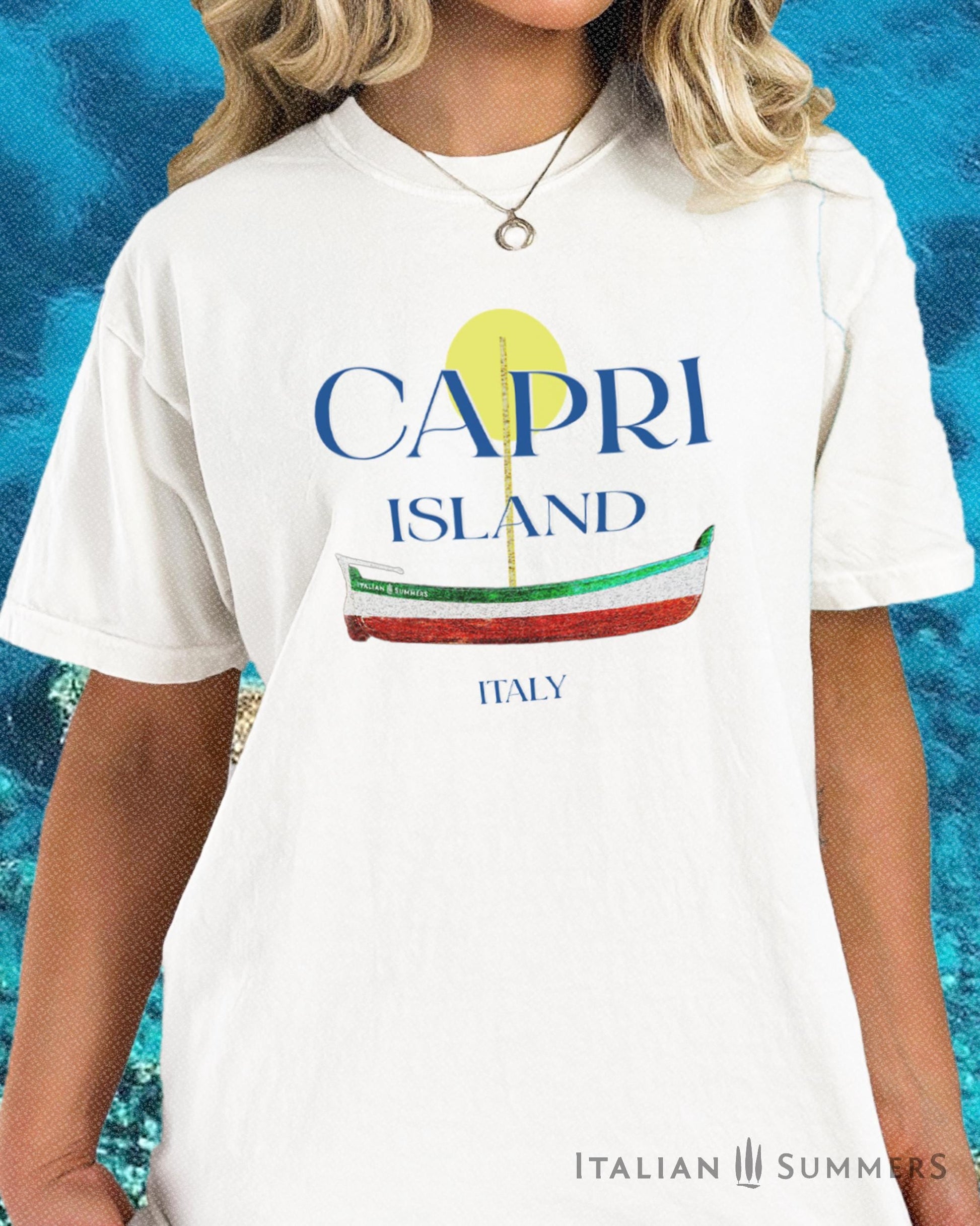 A Garment-dyed quality white T shirt with a print of a traditional Capri Island wooden boat in the color of the Italian flag, and the text CAPRI in capital letters above it, with a full-moon disk above.