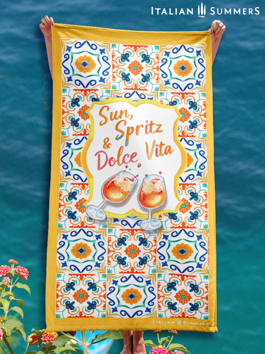Beach towel with Amalfi Coast tile design in Mediterranean colors, featuring Sun, Spritz & Dolce Vita crest with two Aperol Spritz glasses designed by Italian Summers