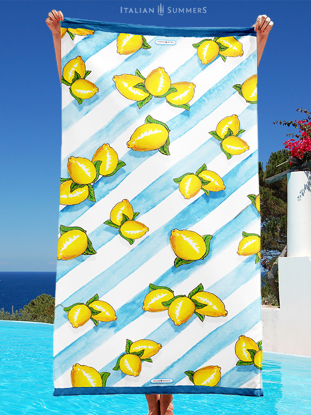 A large beach towel with printed Sorrento lemons on a background of aqua blue water color stripes. A happy and sunny Italian summer feeling. Made by Italian Summers