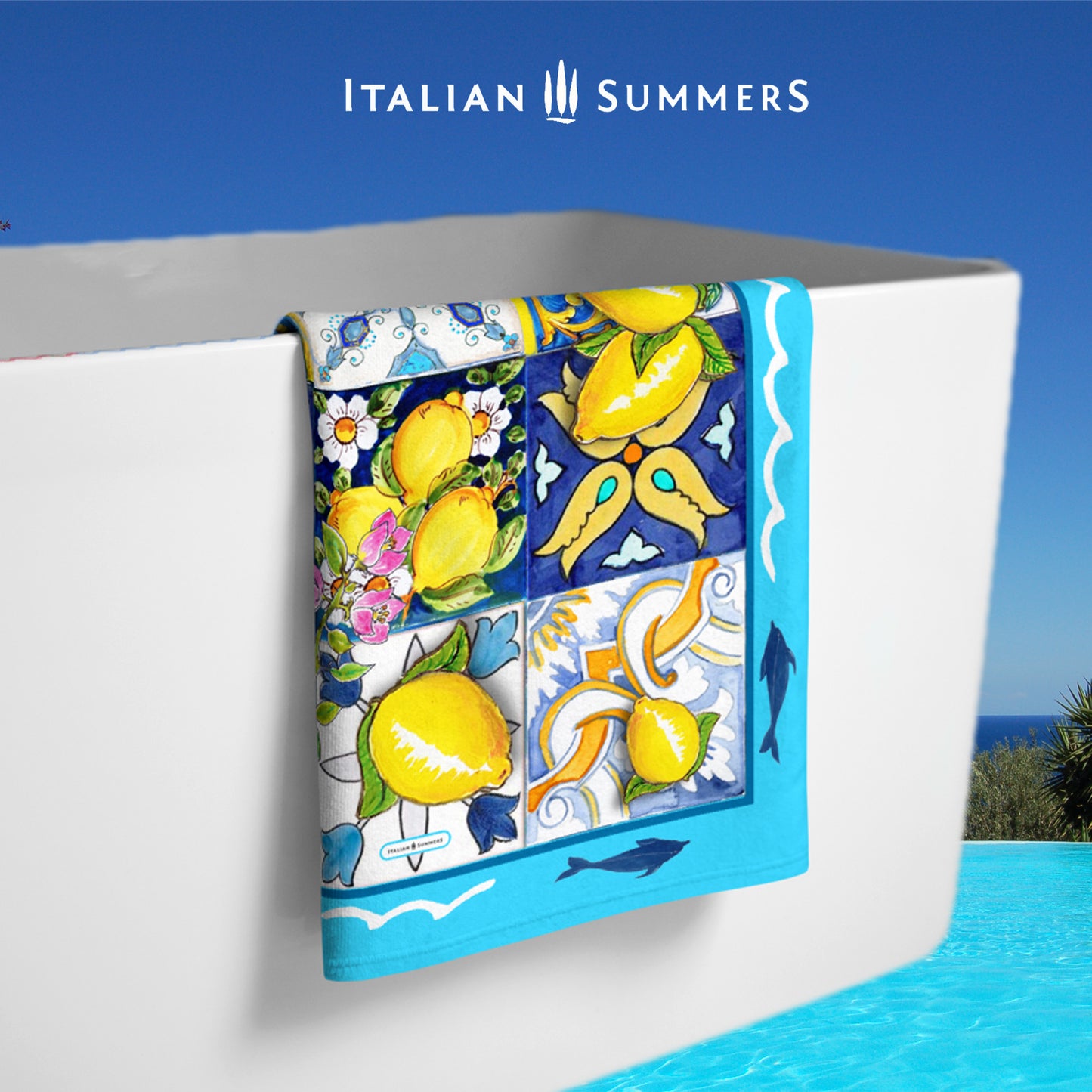 Beautiful Italy inspired beach towel printed with a turquoise rim with dolphins and a field of multi-colored italian maiolica tiles strewn with bunches of Sorrento lemons with flowers. Made by Italian Summers