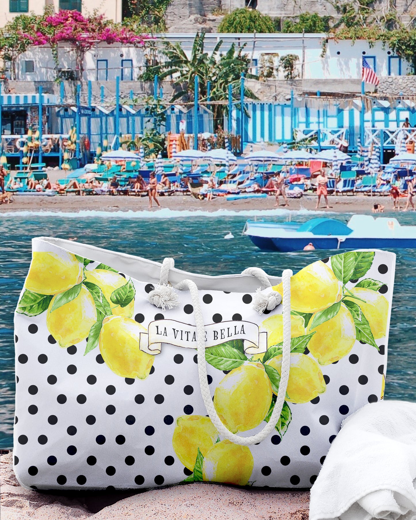 Italy inspired large beach bag with a white background and black polka dots. Big Sorrento lemons on two sides and the writing La vita 'e bella on a scroll in the middle of the bag. Designed by Italian Summers