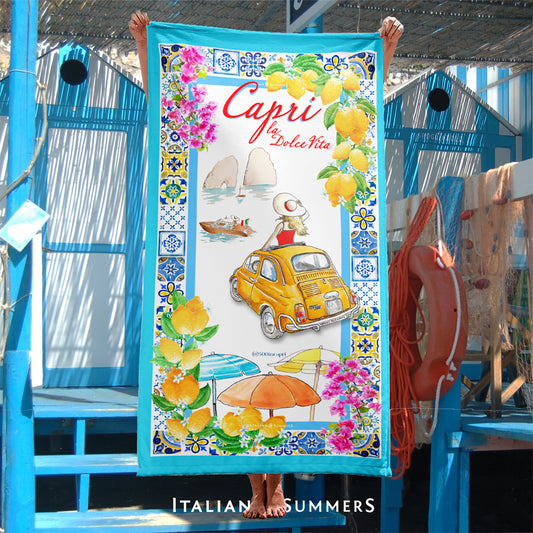 Italy inspired beach towel featuring a frame of colorful maiolica tiles and a view of a vintage yellow FIAT 500 car on Capri Island with a lady in a red dress with a large straw hat standing out of the car's sun roof and looking onto the Faraglioni. Made by Italian Summers