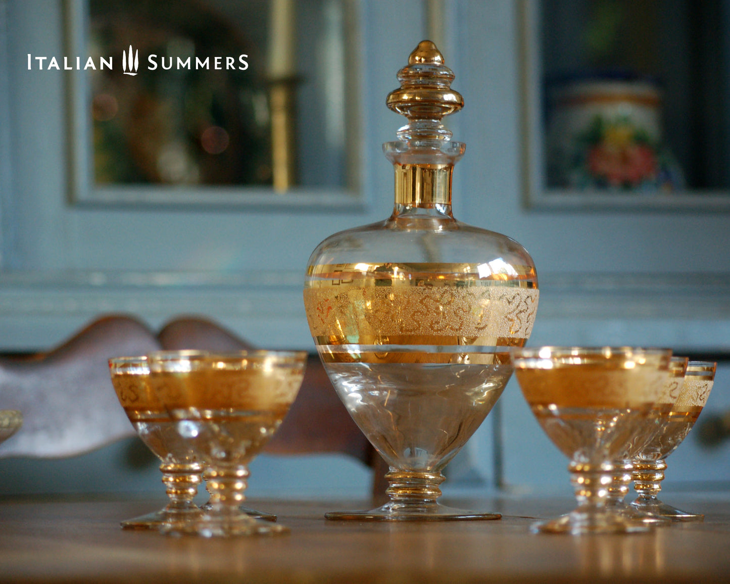 Decorative glass decanter and goblets with 'Italian Summers' branding.