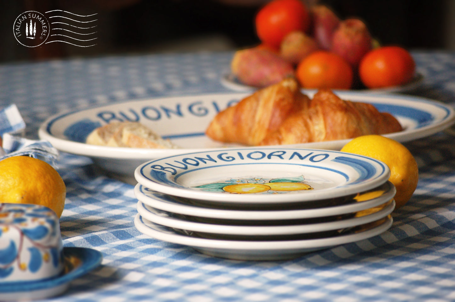 Ceramic plate Buongiorno Limoni handpainted in Sicily. This  plate has the quote Biongiorno on the rim - handpainted  - And colorfull lemons on the center of the plate  with lemon flowers. On the rim of the plate there are blue paint stripes. The blue color is ultra marine. This plate is designed and sold by Italian Summers.