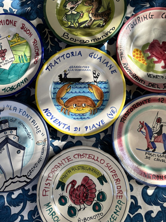 A colorful collection of handpainted vintage Italian restaurant plates, each with an Italian restaurant, Italian recipe and Italian location