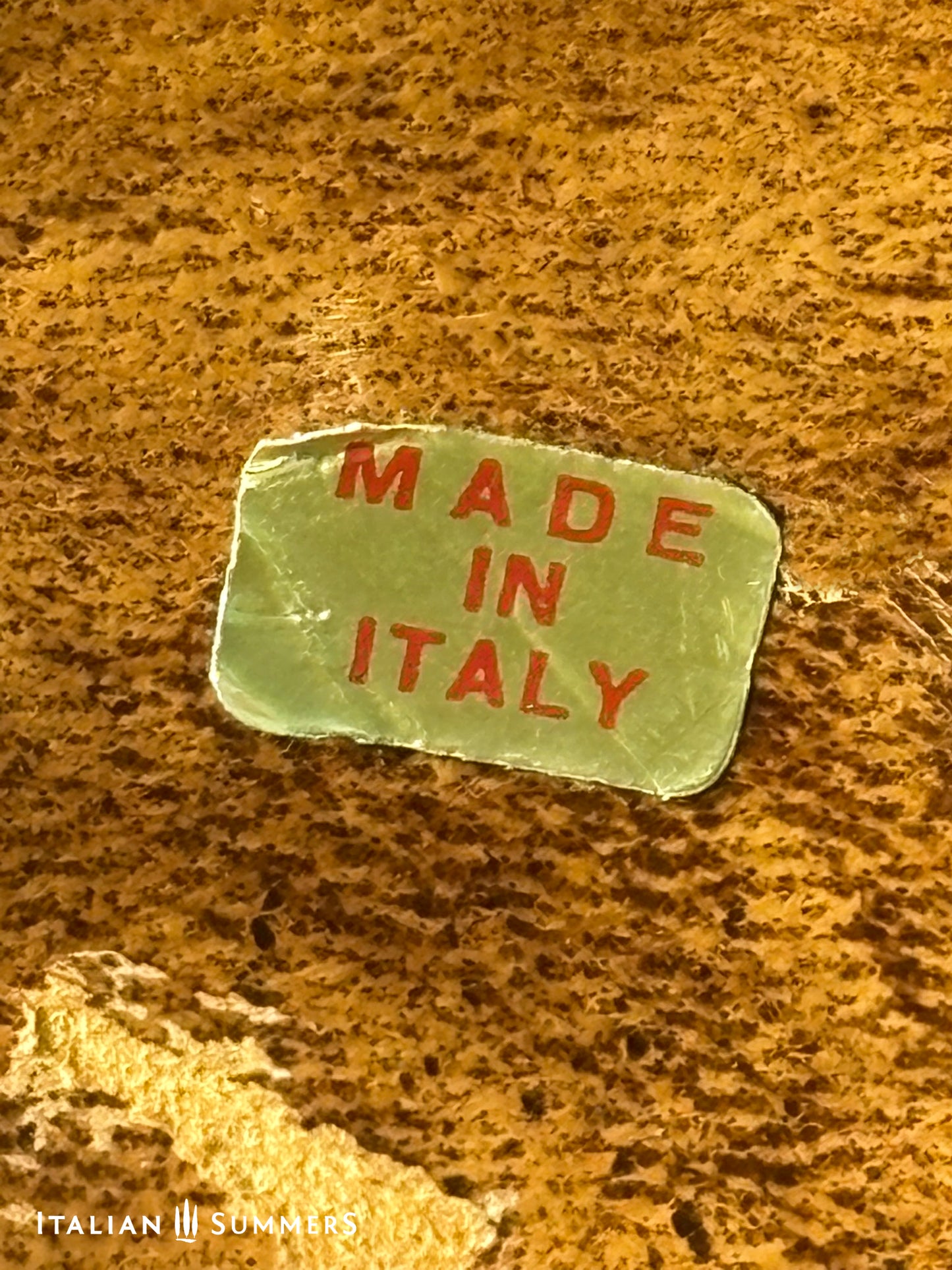 Small 'Made in Italy' sign on a textured surface with 'Italian Summers' branding.
