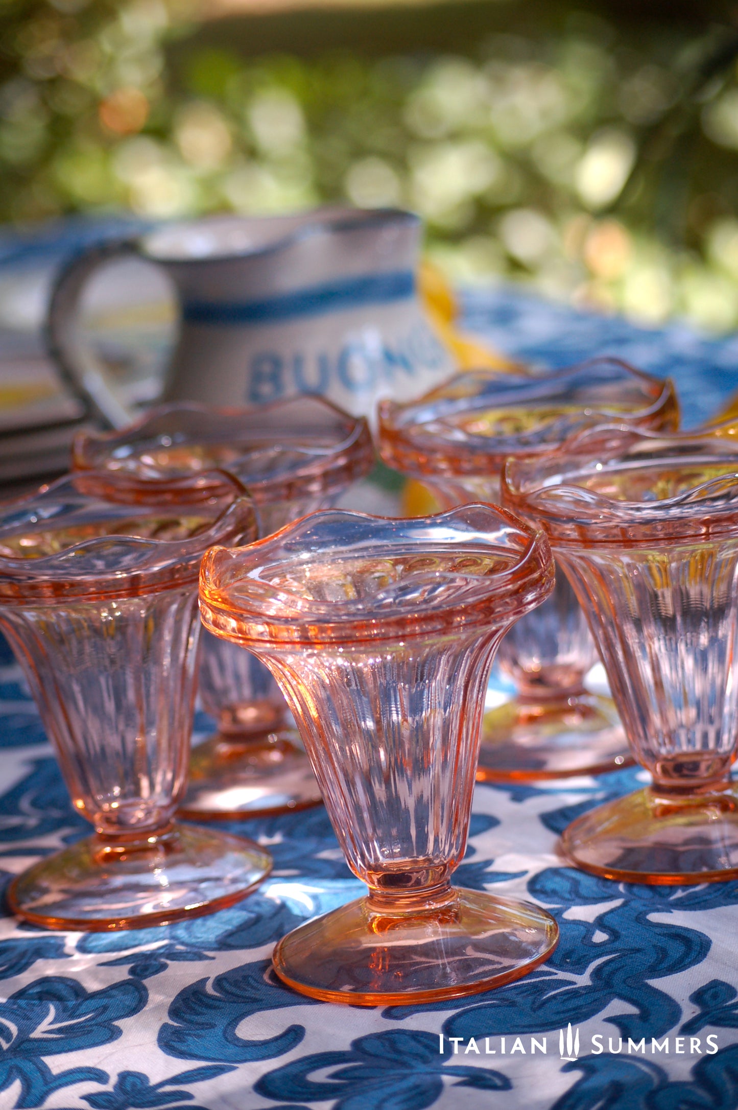 Set of vintage pink French glass dessert dishes on a table with 'Italian Summers' branding.