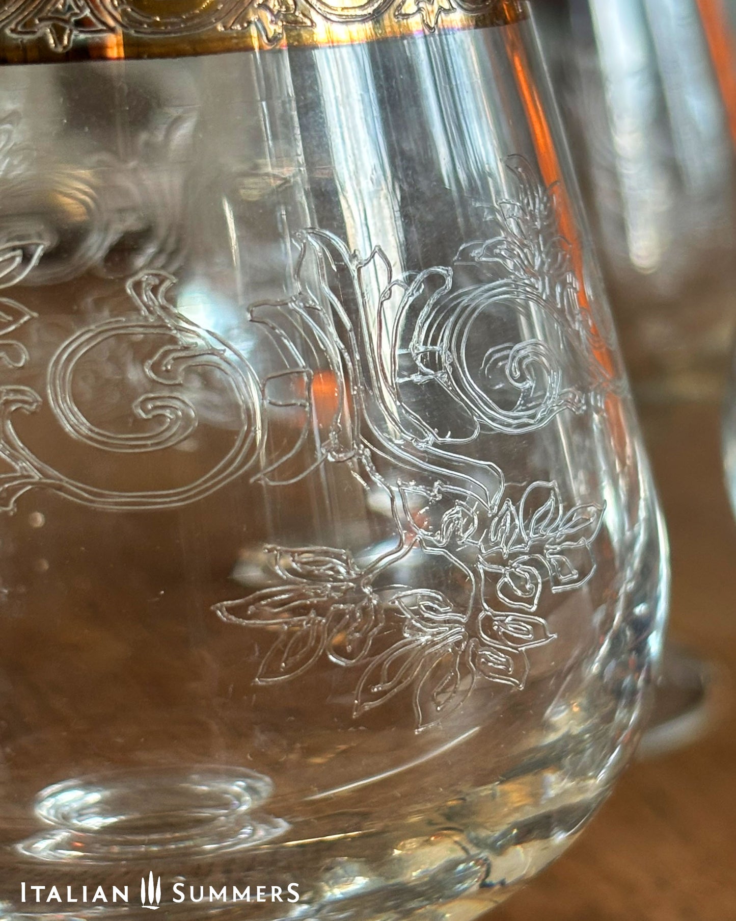Close-up of a glass with intricate engravings and 'Italian Summers' branding.