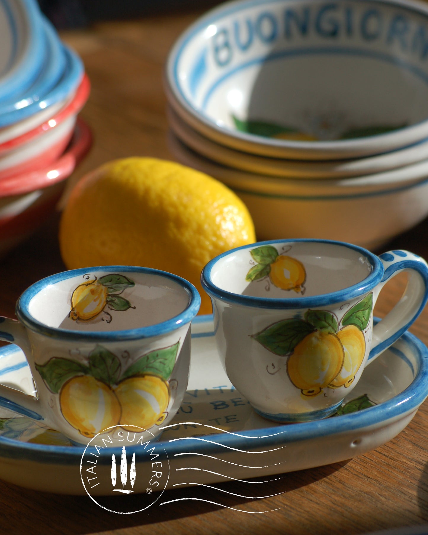 A bright and colorful Italian Maiolica ceramic espresso coffee set, two demitasse and a serving tray featuring sunny Sicilian lemons and a blue decoration with the Italian text -La vita e&#39; piu bella con te-.  hand made in Sicily