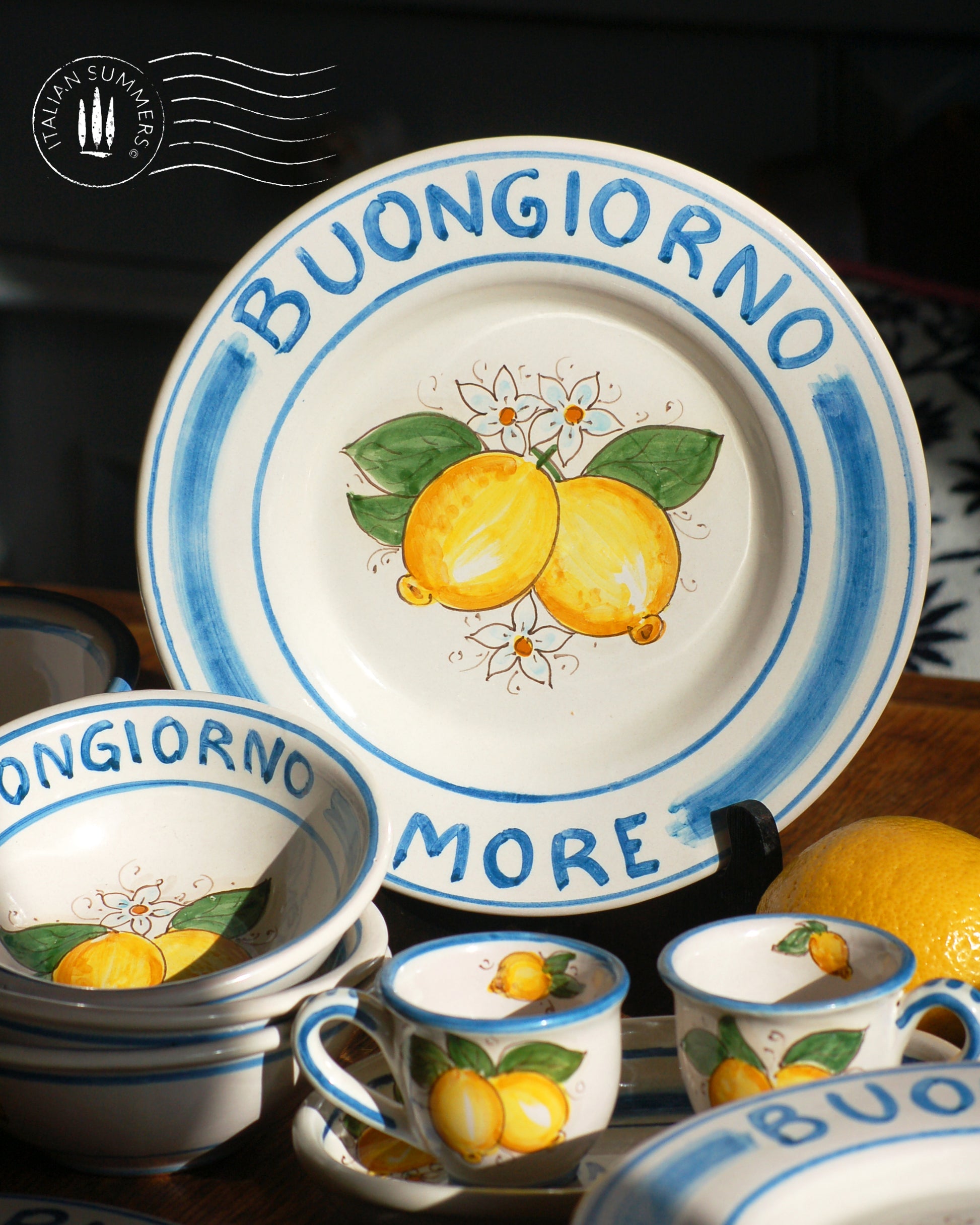 A bright and colorful Maiolica ceramic plate, hand made in Sicily featuring sunny Sicilian lemons and a blue decoration with the text, Buongiorno Amore, which means, Good Morning my Love in Italian.