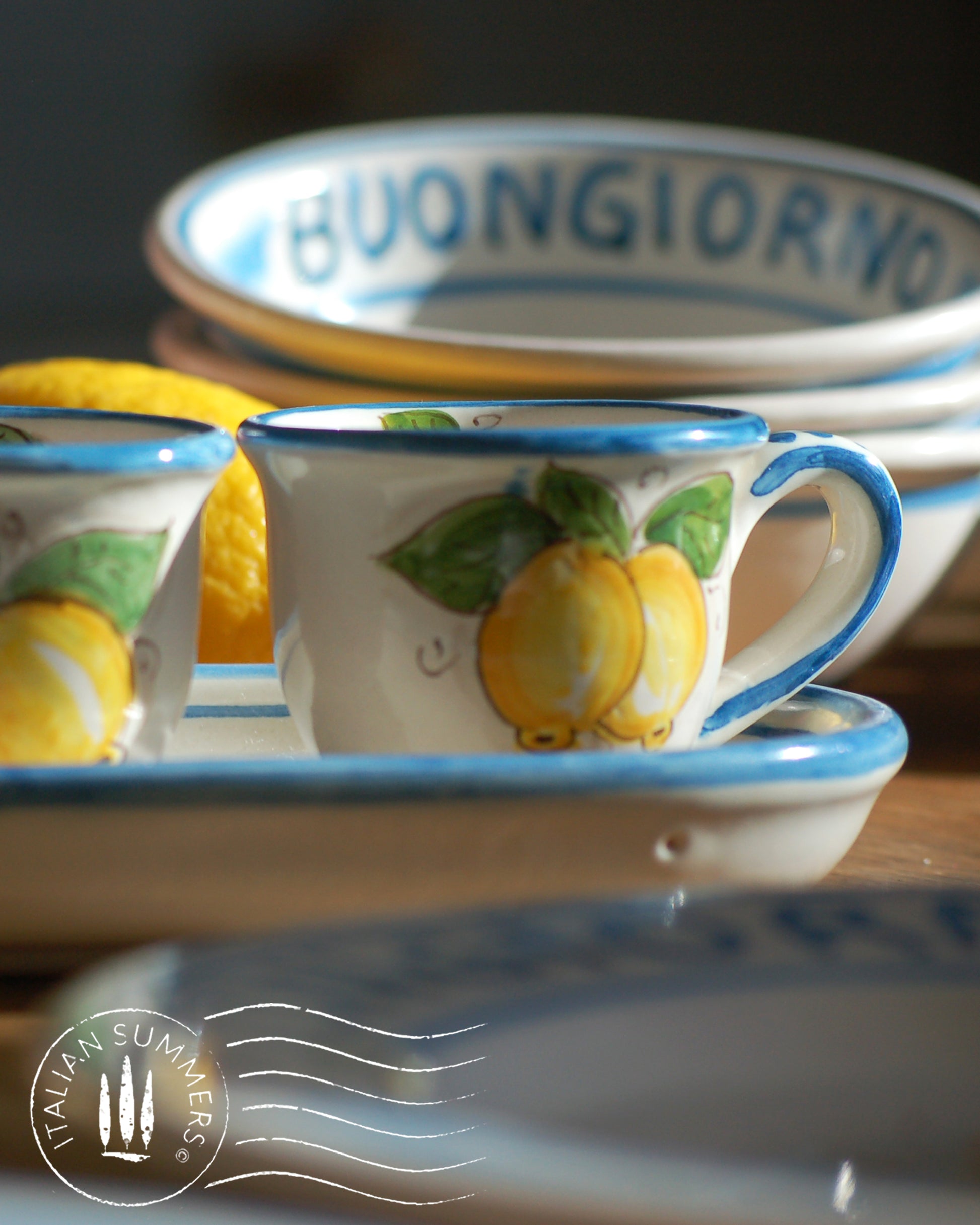 A bright and colorful Italian Maiolica ceramic espresso coffee set, two demitasse and a serving tray featuring sunny Sicilian lemons and a blue decoration with the text Buongiorno which means Good Morning in Italian.  hand made in Sicily