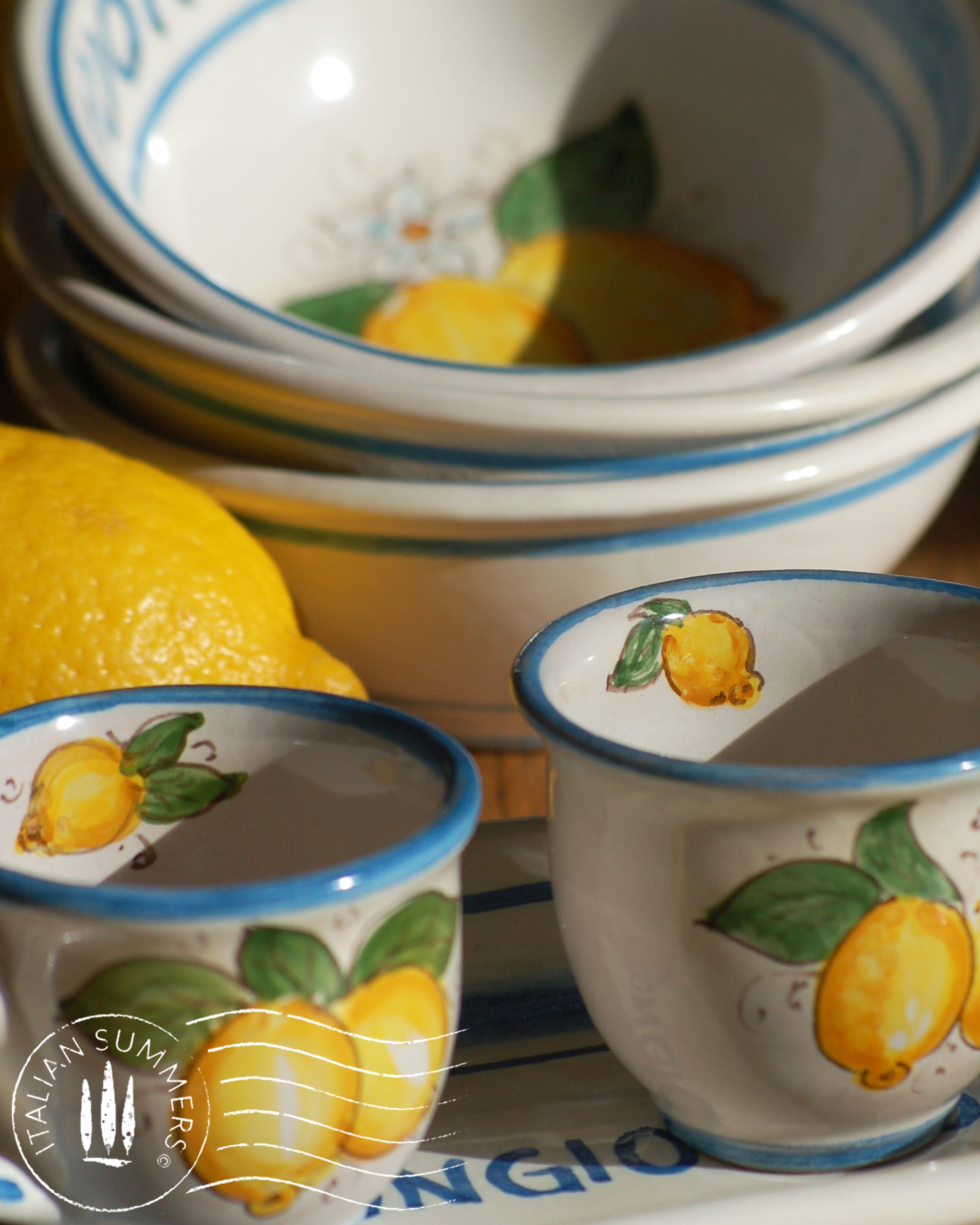A bright and colorful Italian Maiolica ceramic espresso coffee set, two demitasse and a serving tray featuring sunny Sicilian lemons and a blue decoration with the text Buongiorno which means Good Morning in Italian.  hand made in Sicily
