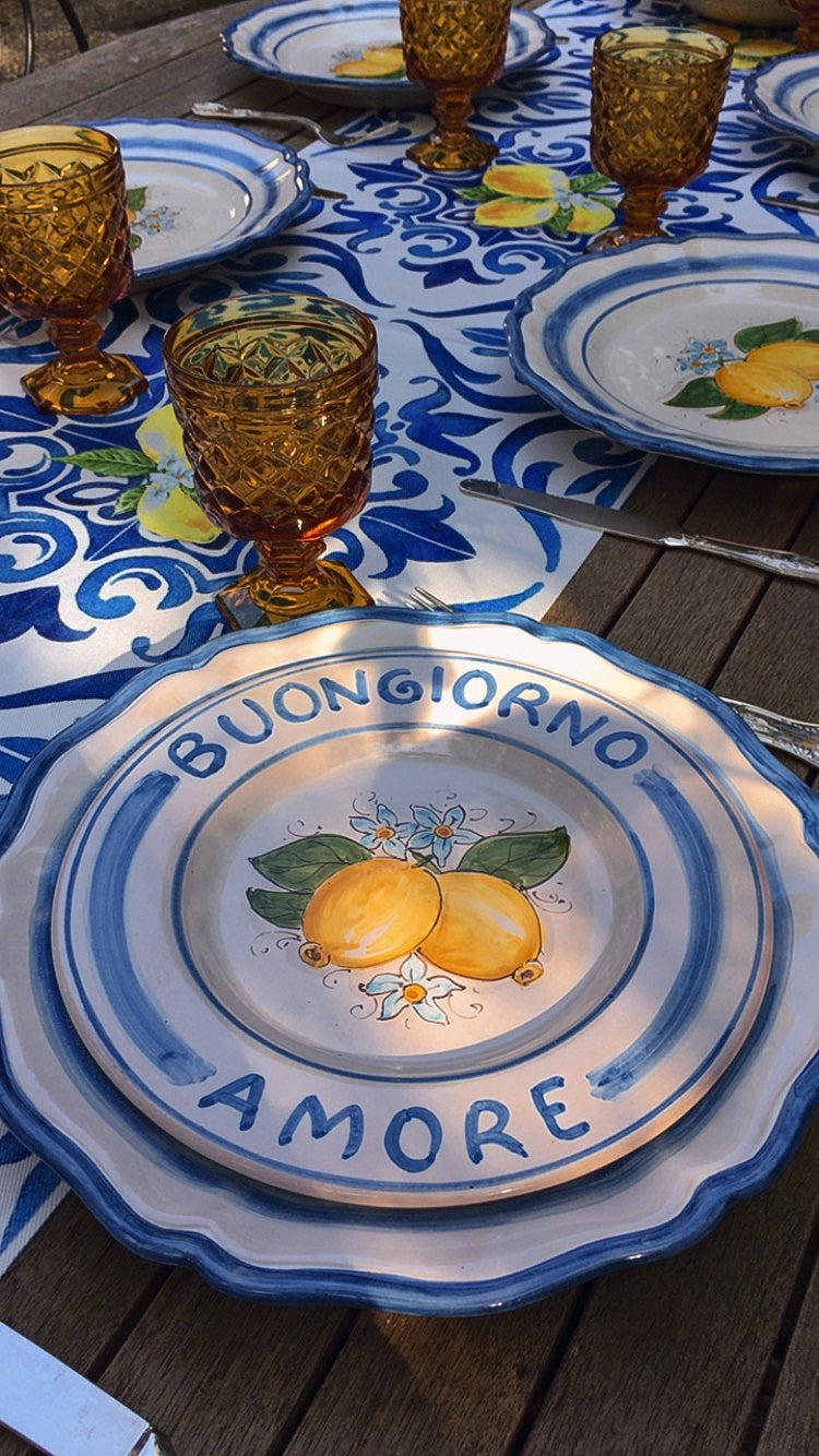 A custom made Italian maiolica ceramic dinner plate decorated with bright Sorrento Lemons and light blue stripes around the scalloped edge and in the  inside of the plate framing the lemons. 