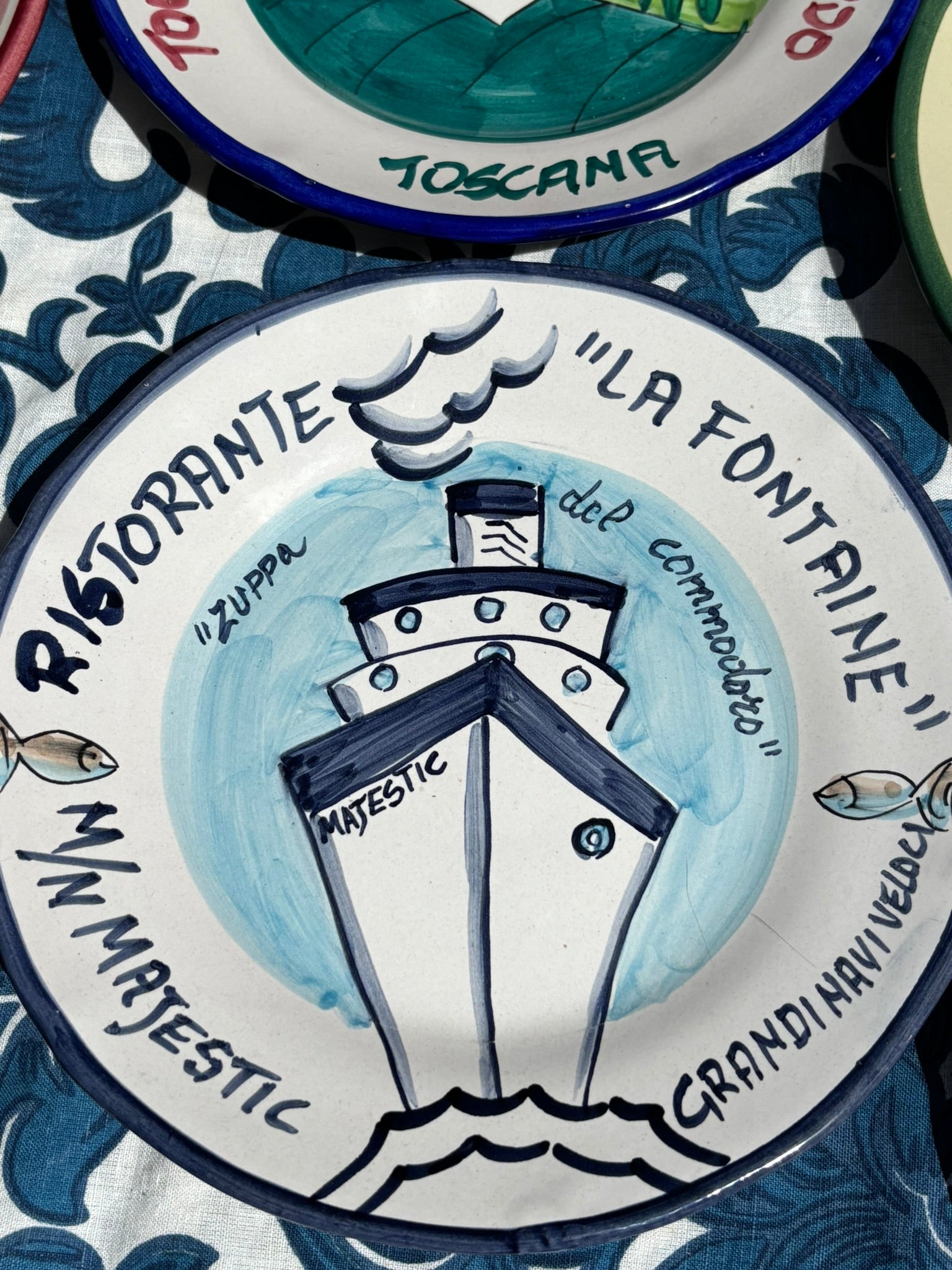 Italian decorative plate in ceramic with a handpainted ship illustration and text, Ristorante La Fontaine. Majestic Grandi Navi Veloci. All in navy blue color