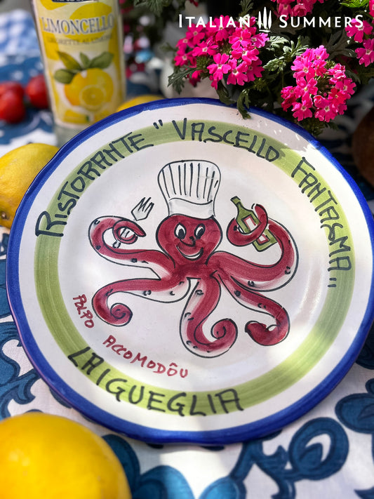 Italian vintage Decorative plate with an octopus design and Italian  text, placed on a table with lemons and flowers.