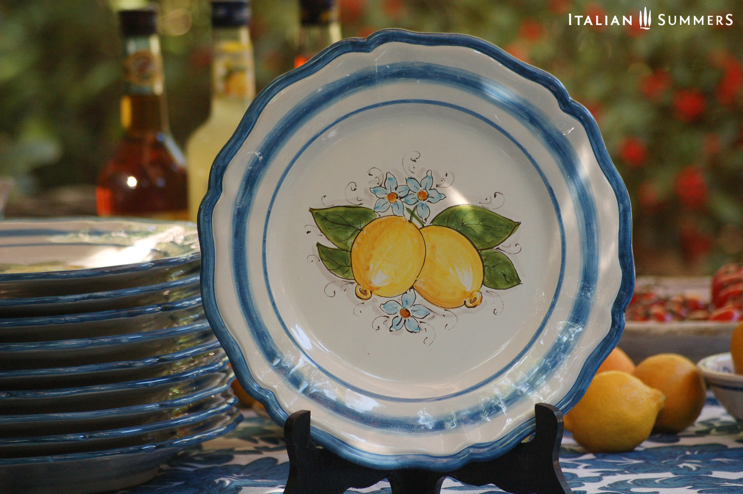 A custom made Italian maiolica ceramic dinner plate decorated with bright Sorrento Lemons and light blue stripes around the scalloped edge and in the  inside of the plate framing the lemons. 